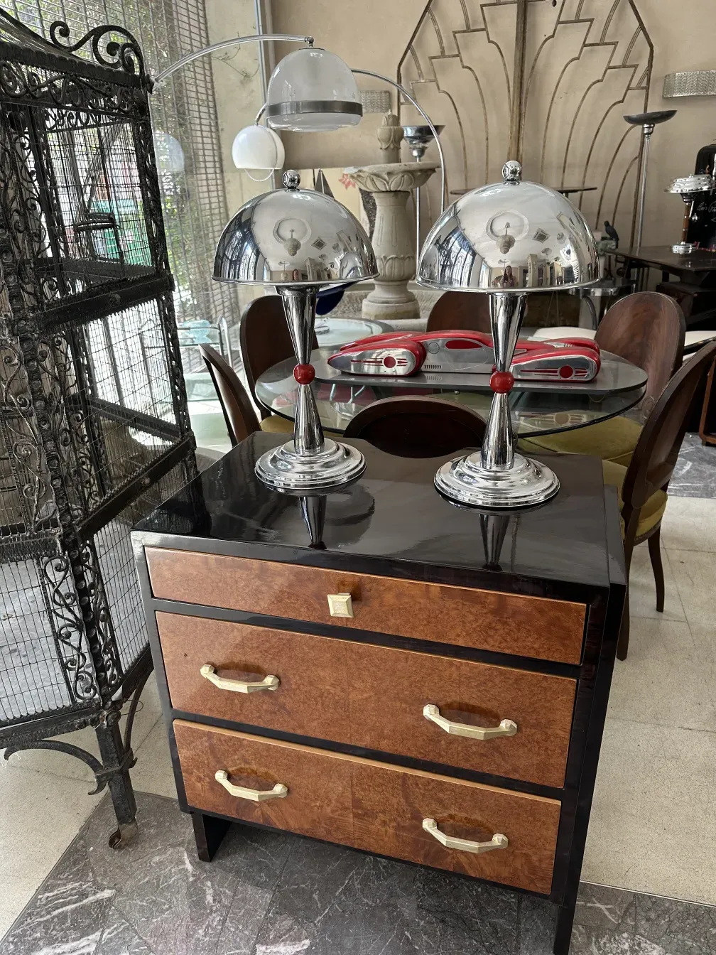 Antique wooden cabinet with elegant finishes and two compartments, adorned with modern lamps in the background.
