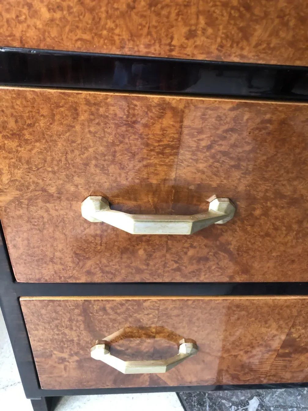 Antike Schublade mit glänzender Oberfläche und goldenen Griffen.