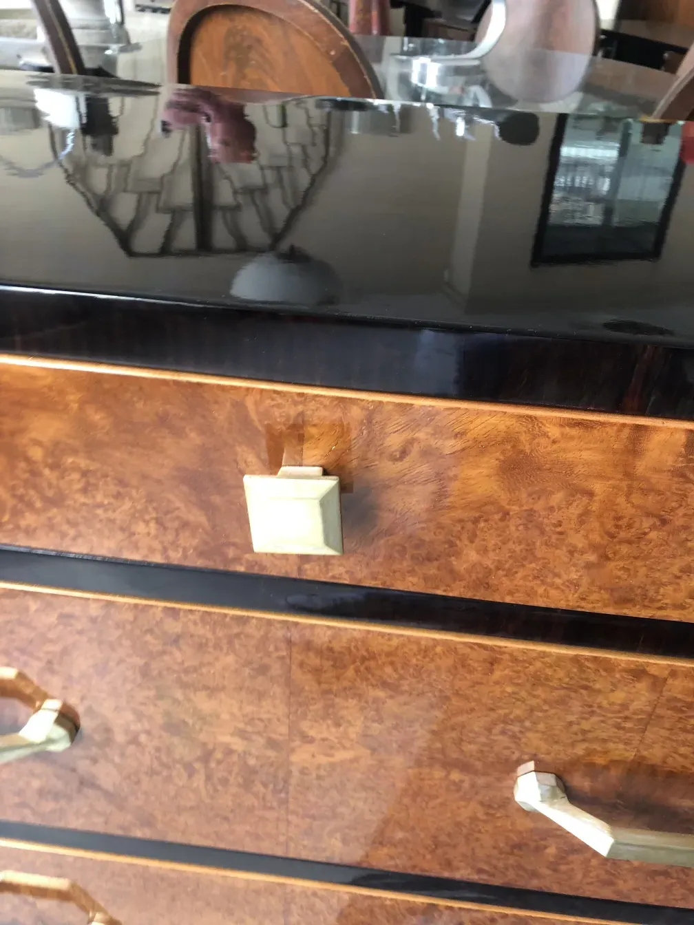 Eleganter antiker Schubladenkasten mit goldenen Kanten und glänzendem Verschluss in klassischer Umgebung.