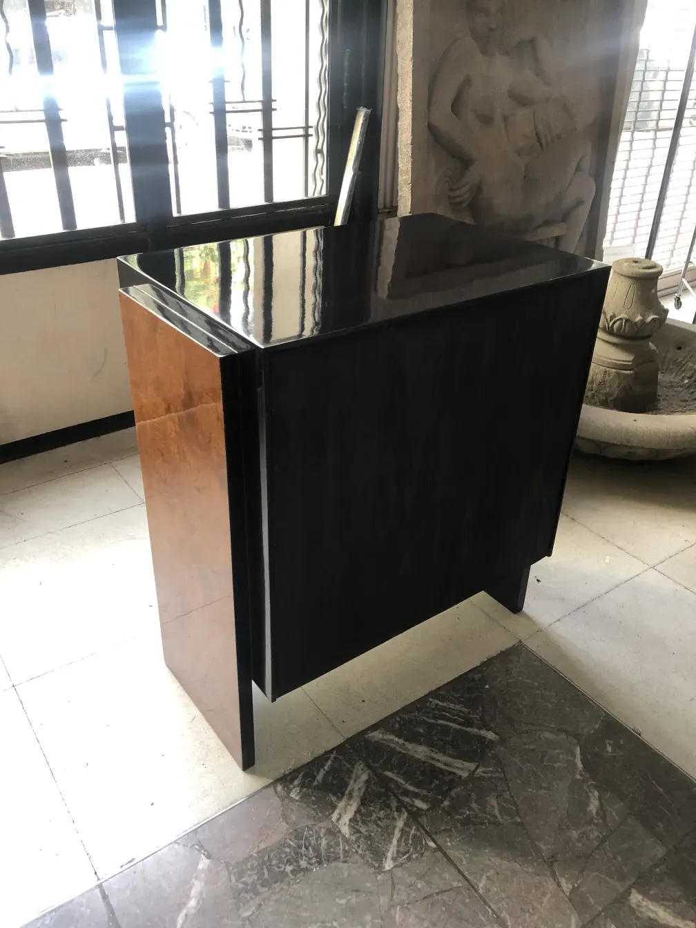 Gaveteira antiga com design elegante, colocada em uma sala com piso de mármore