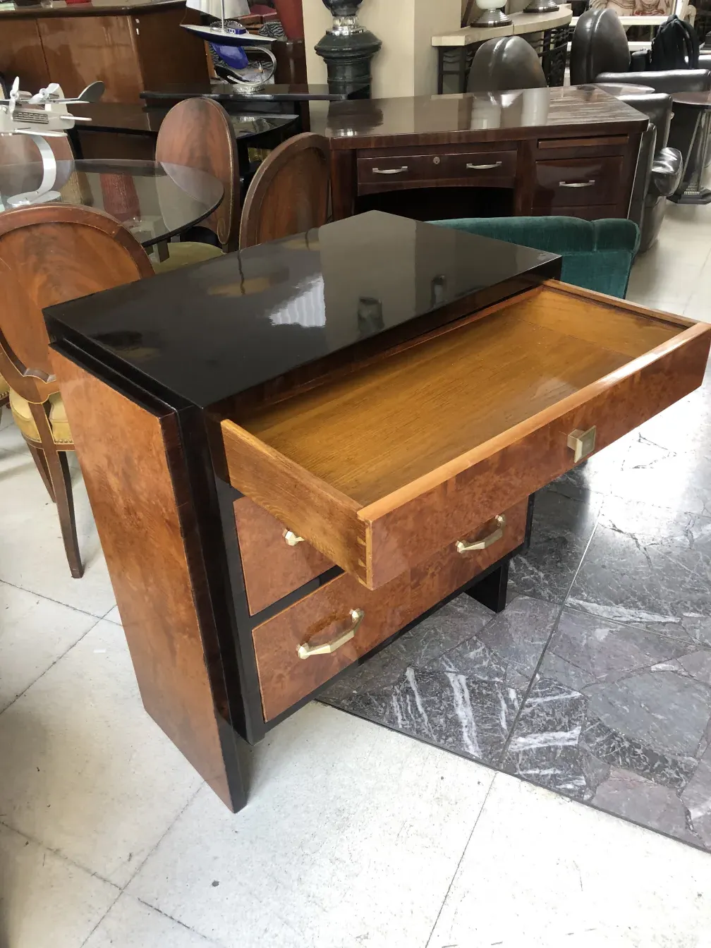 Commode ancienne en bois avec poignées dorées dans un décor vintage.