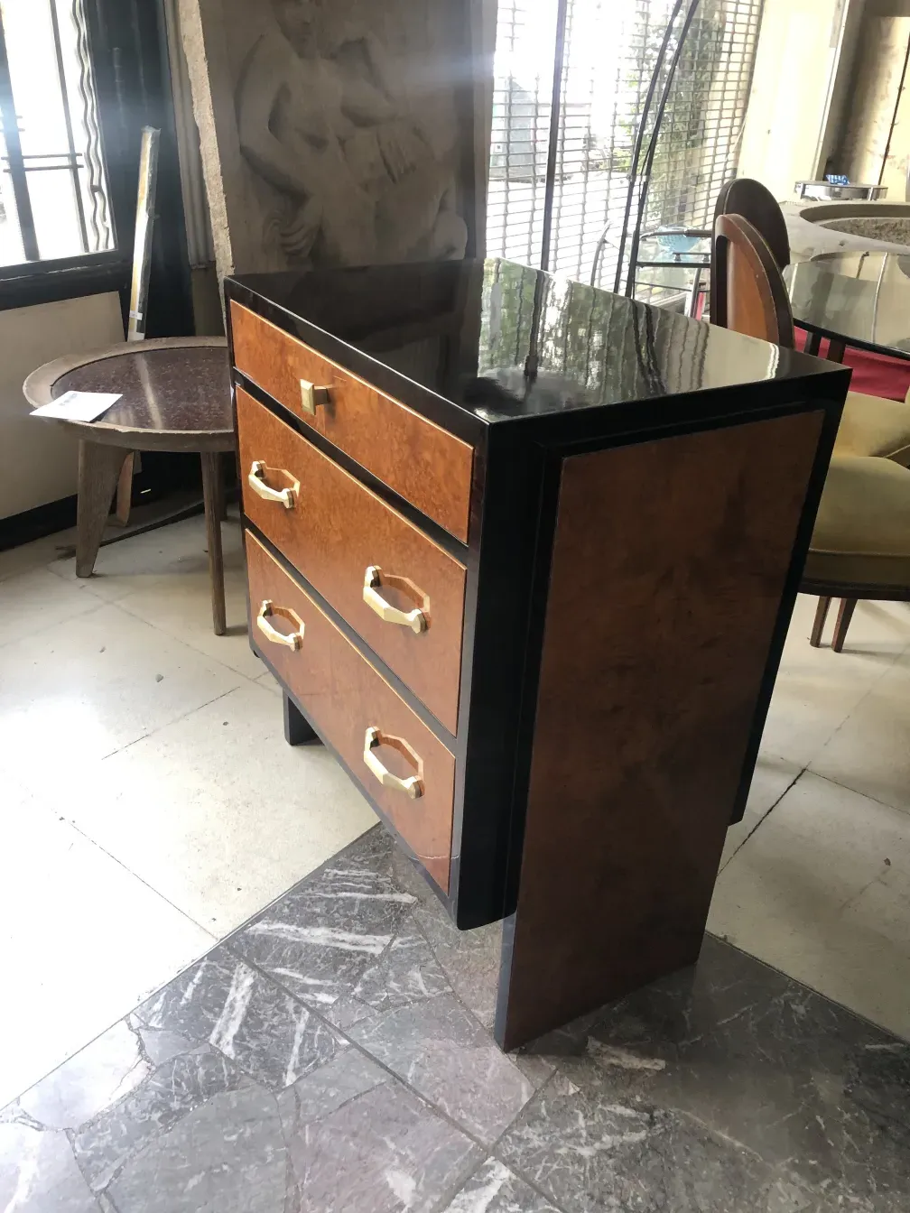 Cómoda antigua de madera con tiradores dorados en un ambiente acogedor.