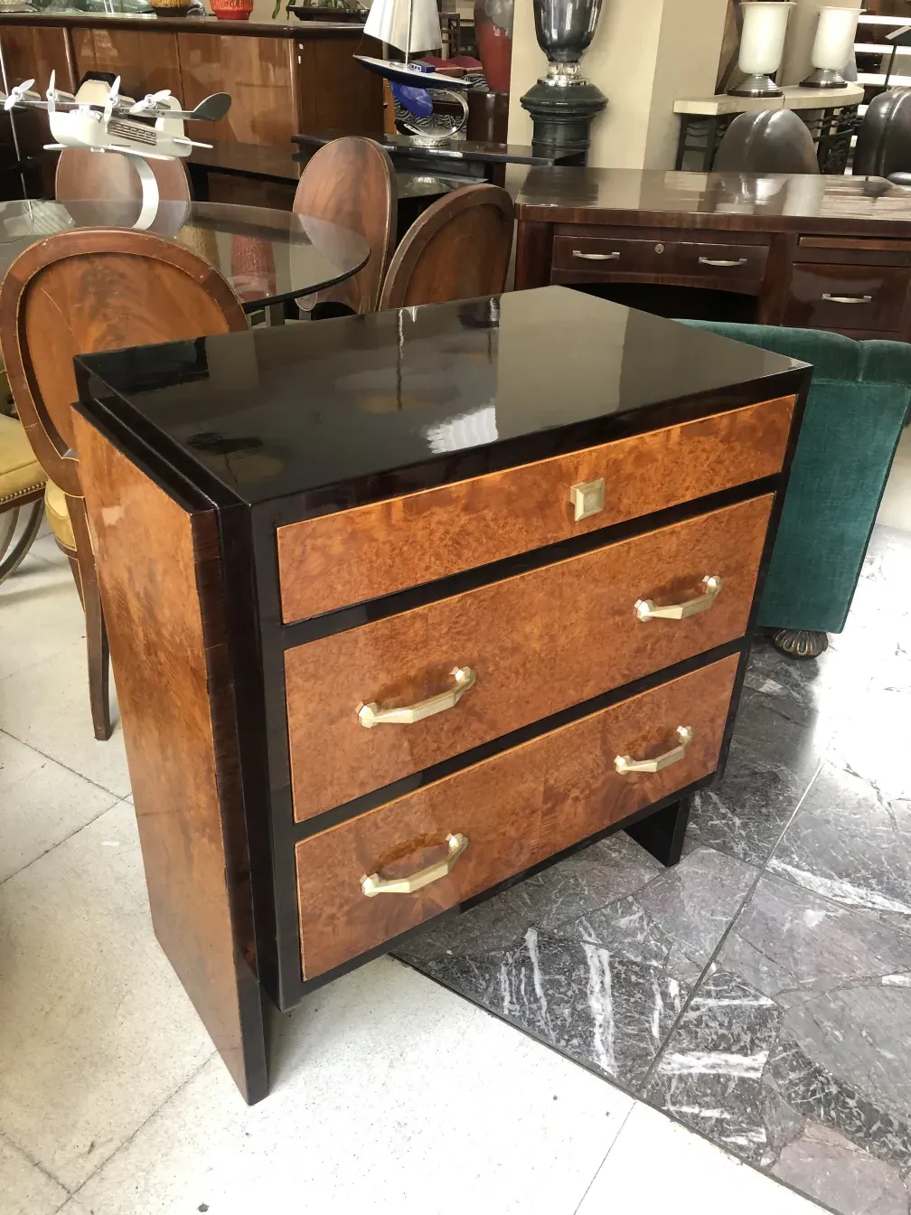 Antike Holzschublade mit goldenen Griffen in einer eleganten Umgebung.