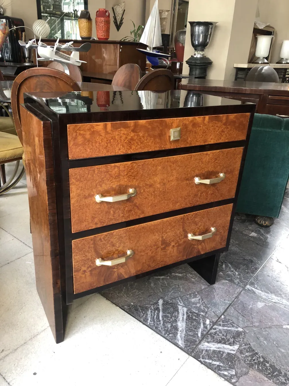 Gaveteira antiga com três gavetas em um ambiente elegante.