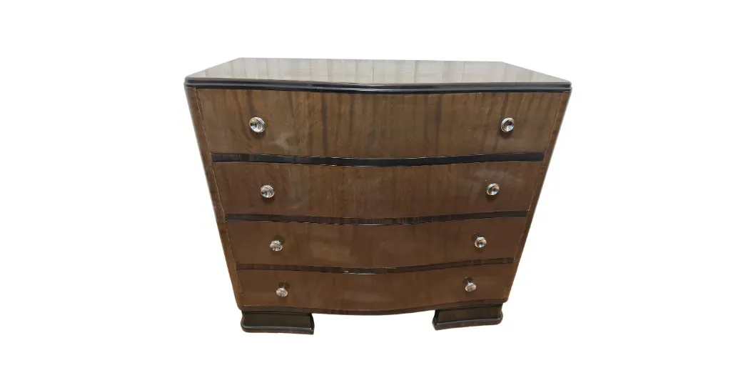 Commode ancienne avec quatre tiroirs et éléments décoratifs.