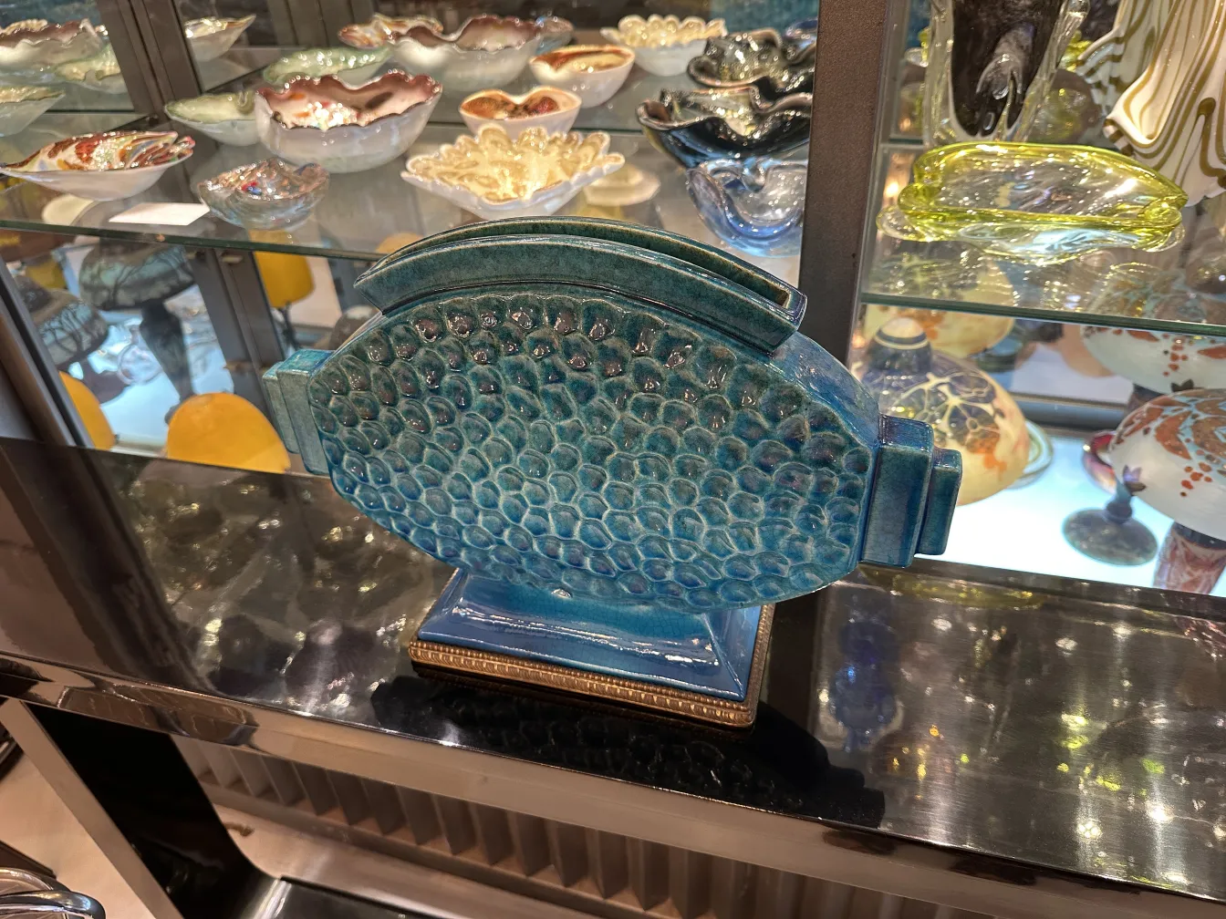 Scultura ceramica antica a forma di pesce, colore blu vivace.