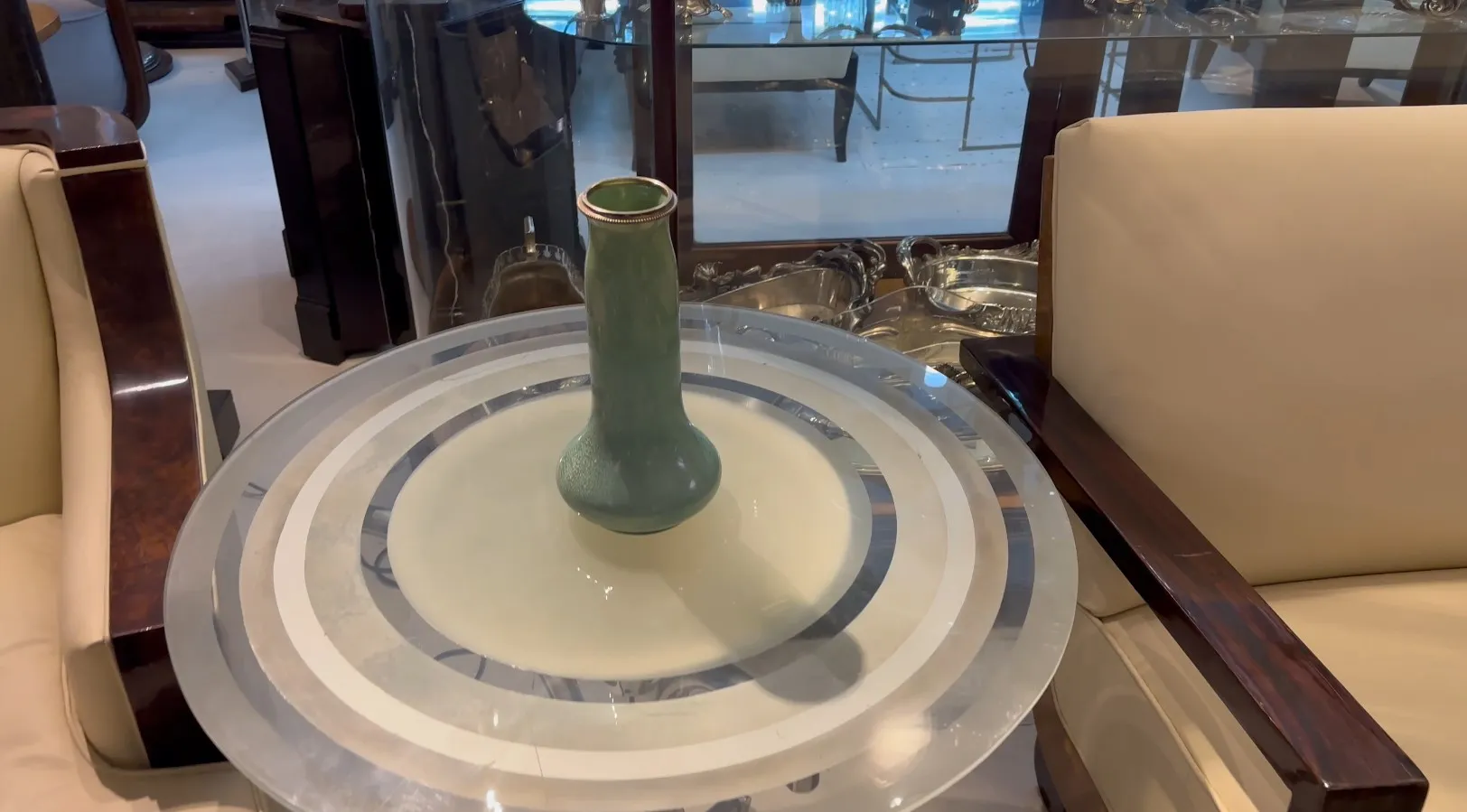 Antique green ceramic vase on a glass table