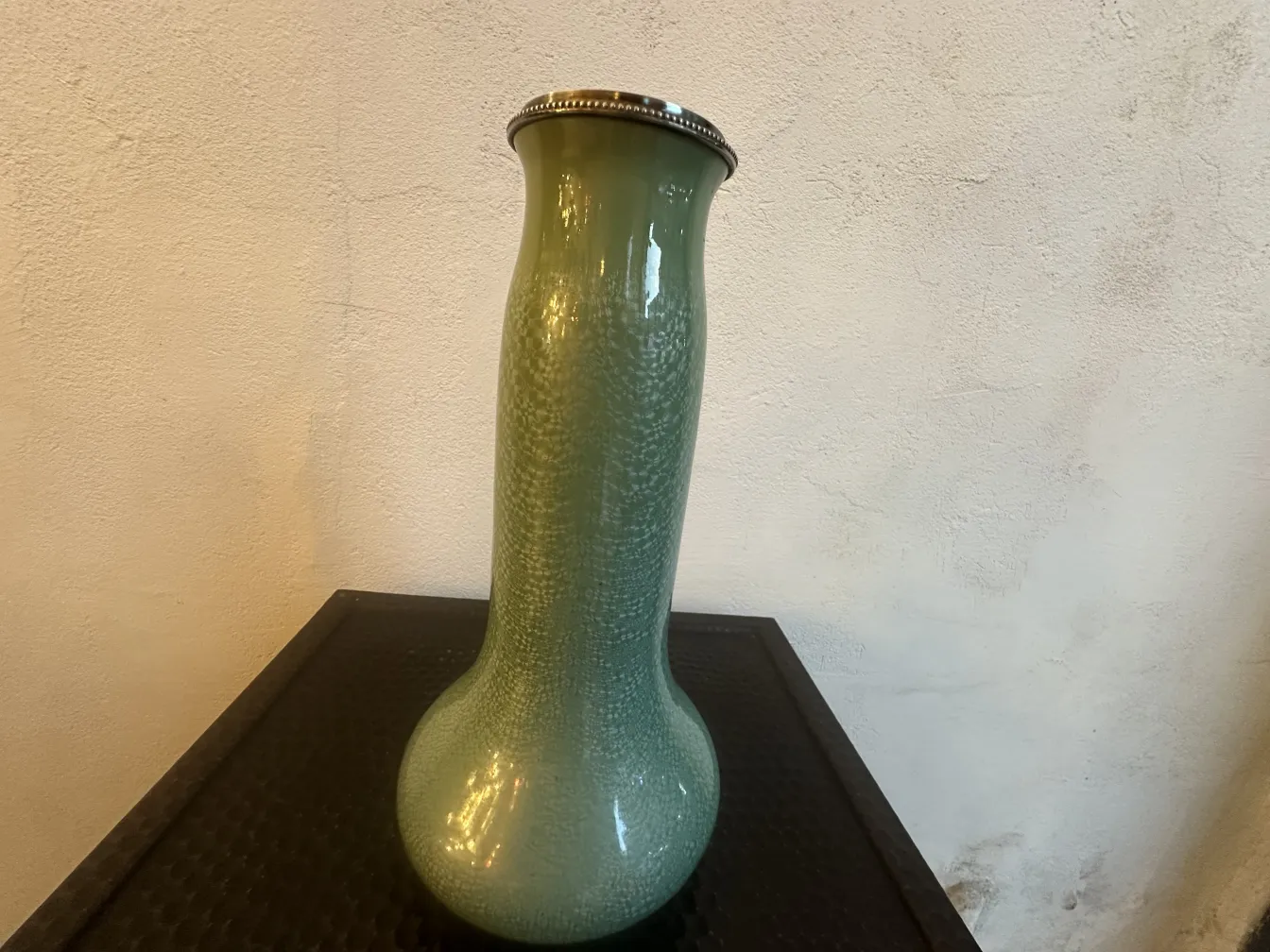 Antique green ceramic vase with decorative rim.