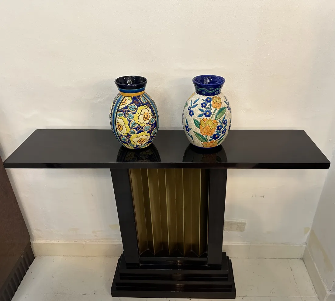 Deux vases en céramique ancienne colorée sur une table noire.