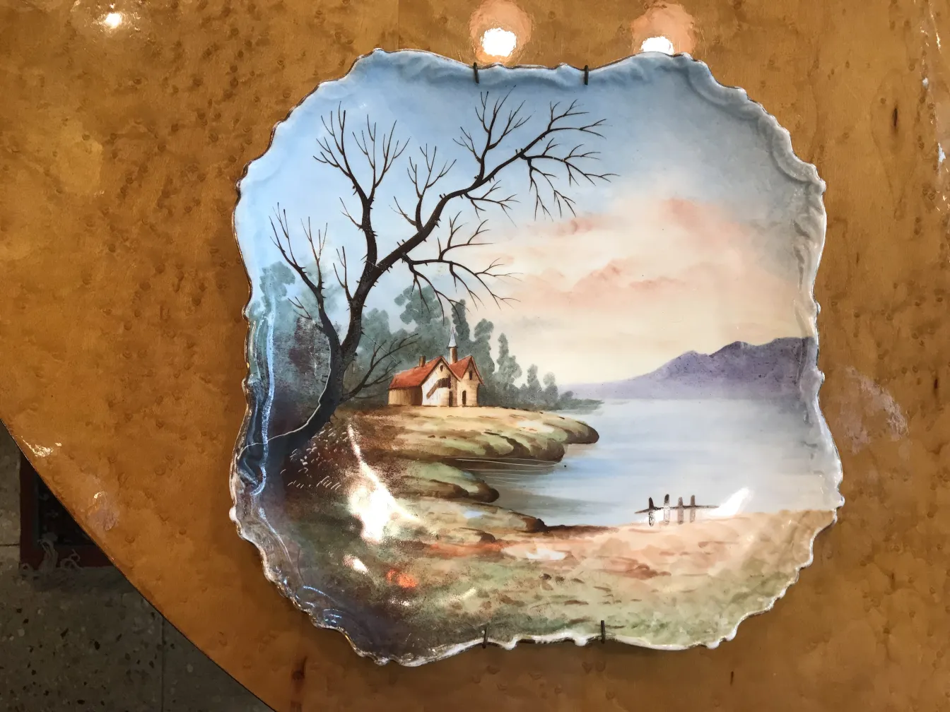 Plato antiguo de cerámica pintada con paisaje sereno y árbol