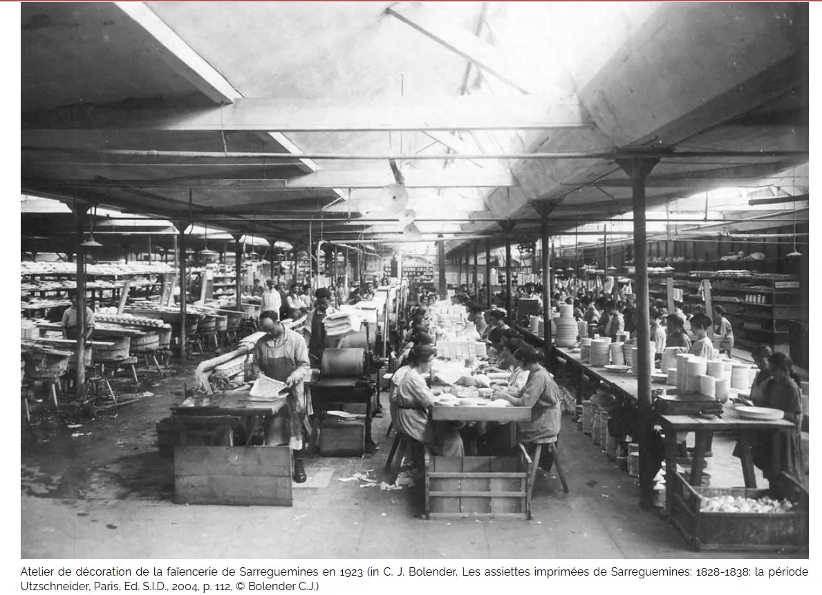 Photographie d'un atelier de céramique ancienne avec des artisans au travail.