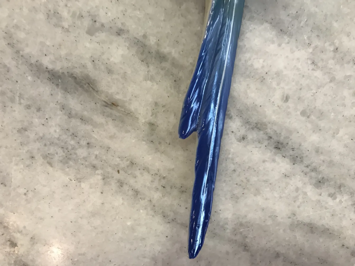 Obra de cerámica antigua en tonos azules brillantes sobre fondo claro.