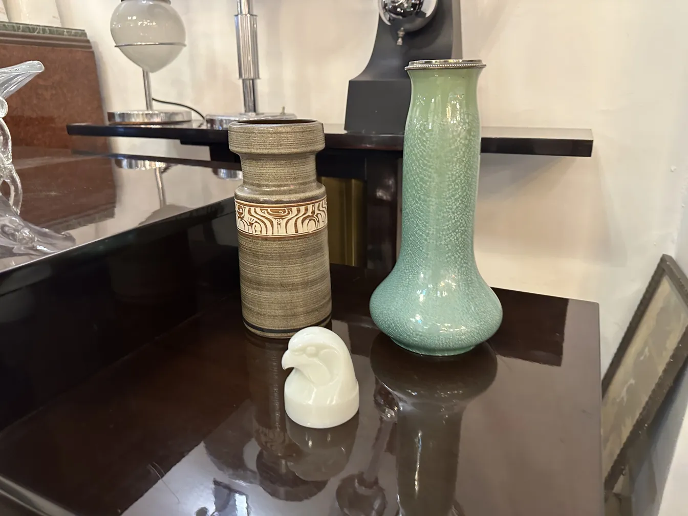 Vaso verde de cerámica antiga, decoração artesanal em fundo neutro.