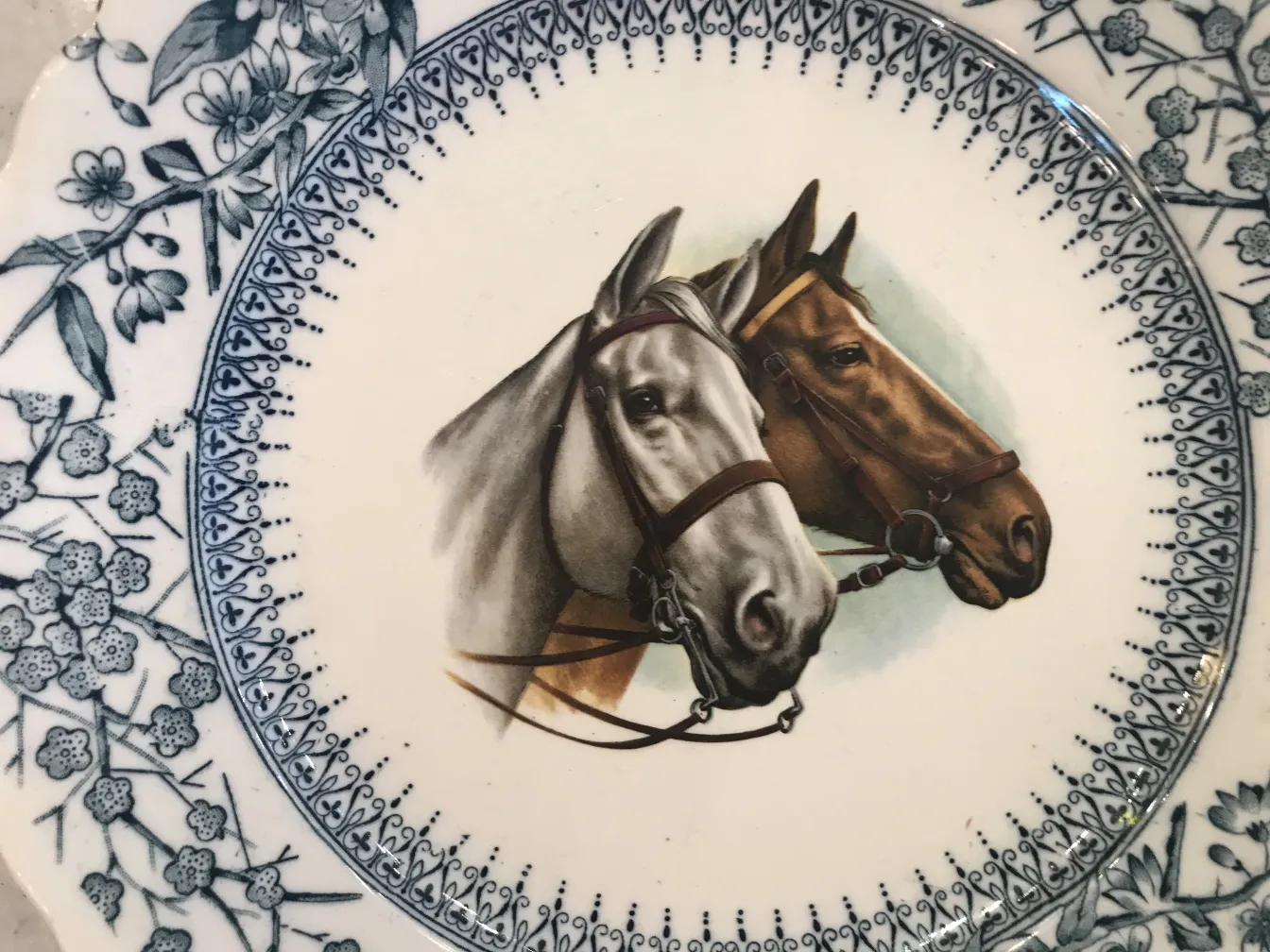 Antique ceramic plate featuring two painted horses.
