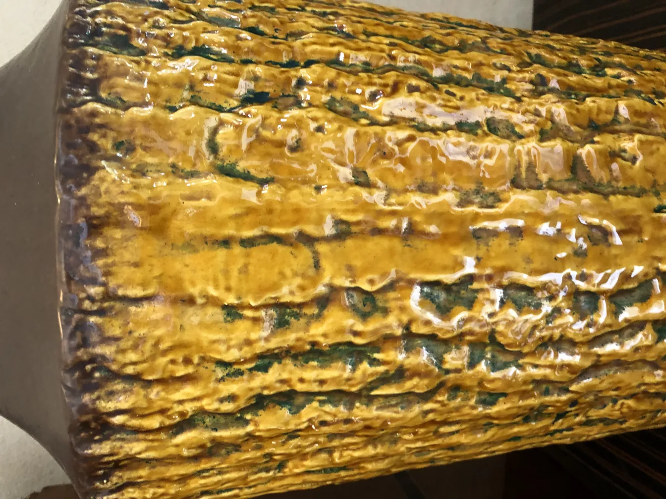 Cerámica antigua con textura amarilla y verde brillante.