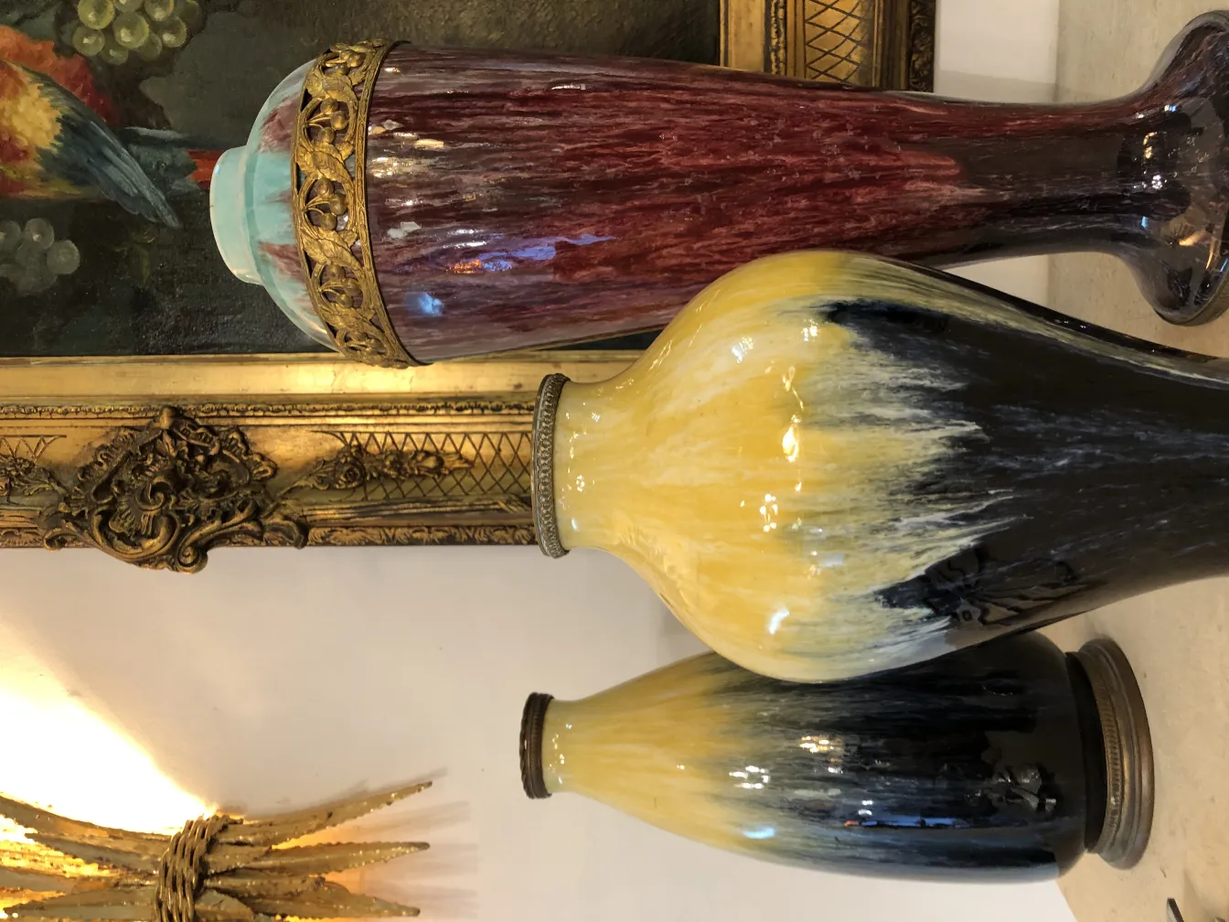 Trois vases en céramique antique de couleurs vives.