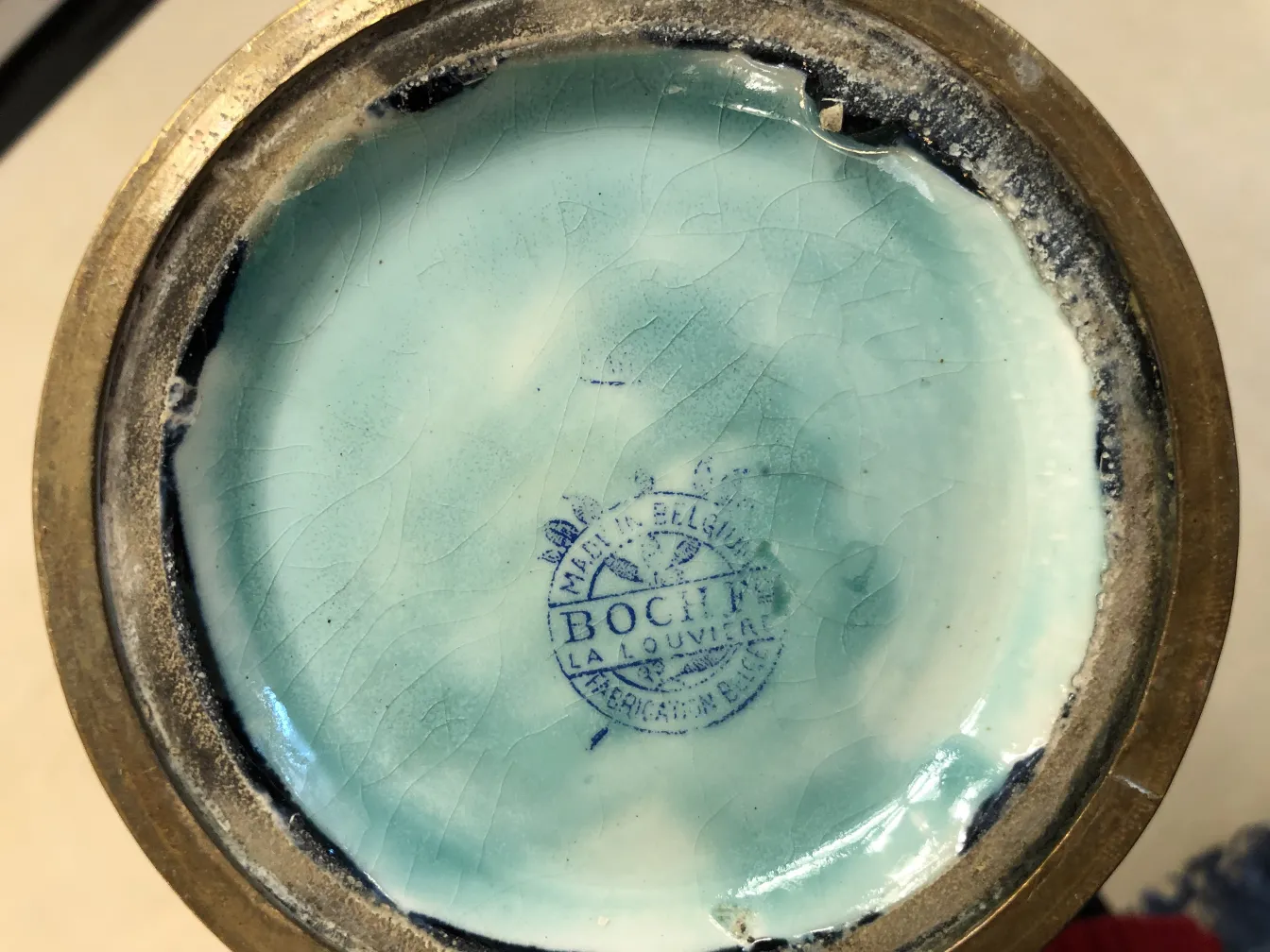 Antique ceramic base with blue stamp in the center.