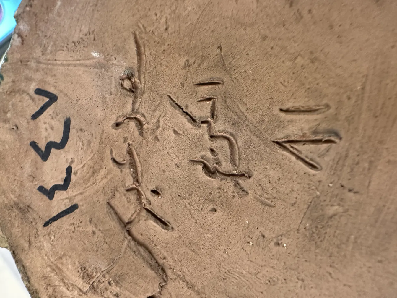 Cerámica antigua con inscripciones en relieve y textura