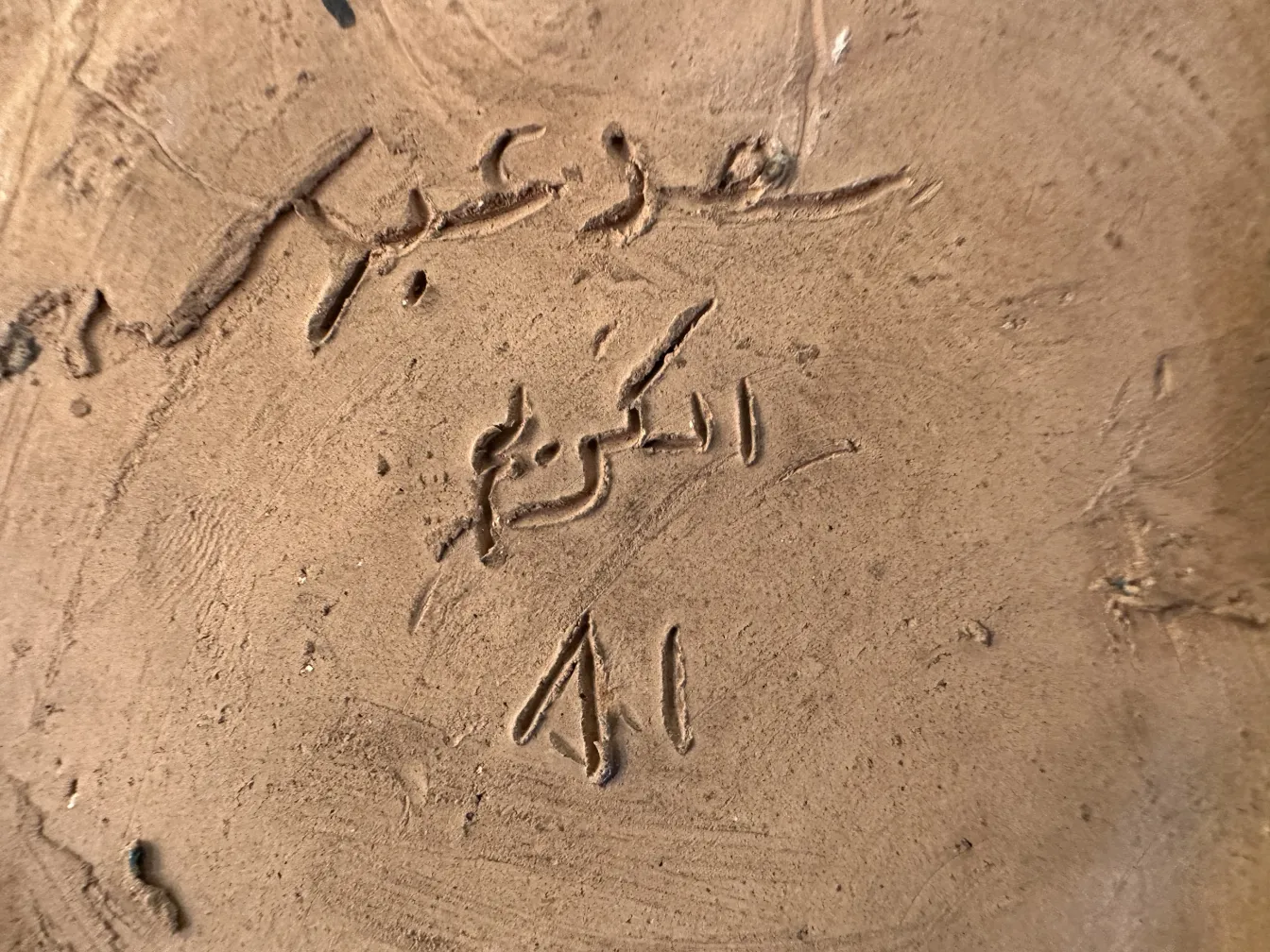 كائن السيراميك القديم مع كتابة وتفاصيل مزخرفة.