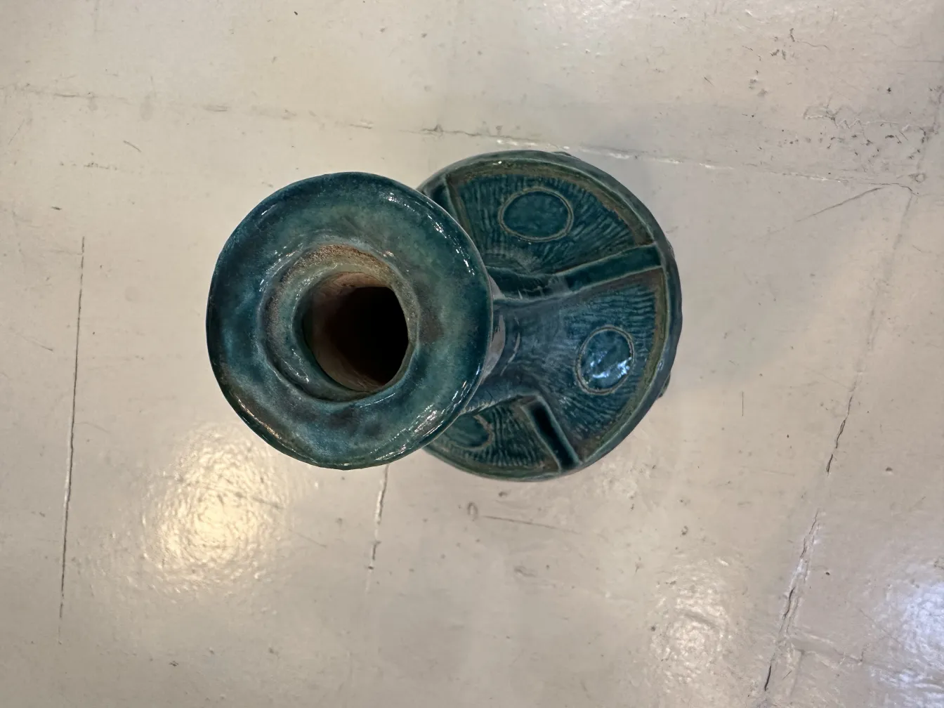 Vaso de cerâmica antiga com decoração azul brilhante.