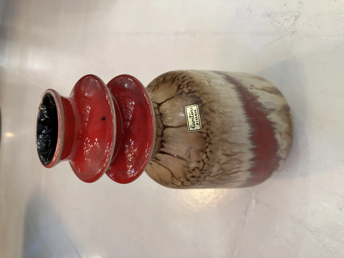 Vaso de cerâmica antiga com design vermelho e marrom.