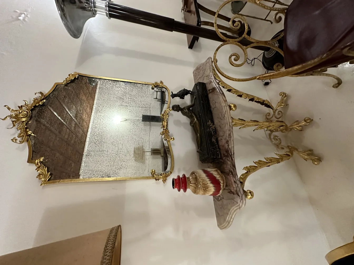 金のフレームと装飾的な陶器のある古い鏡。