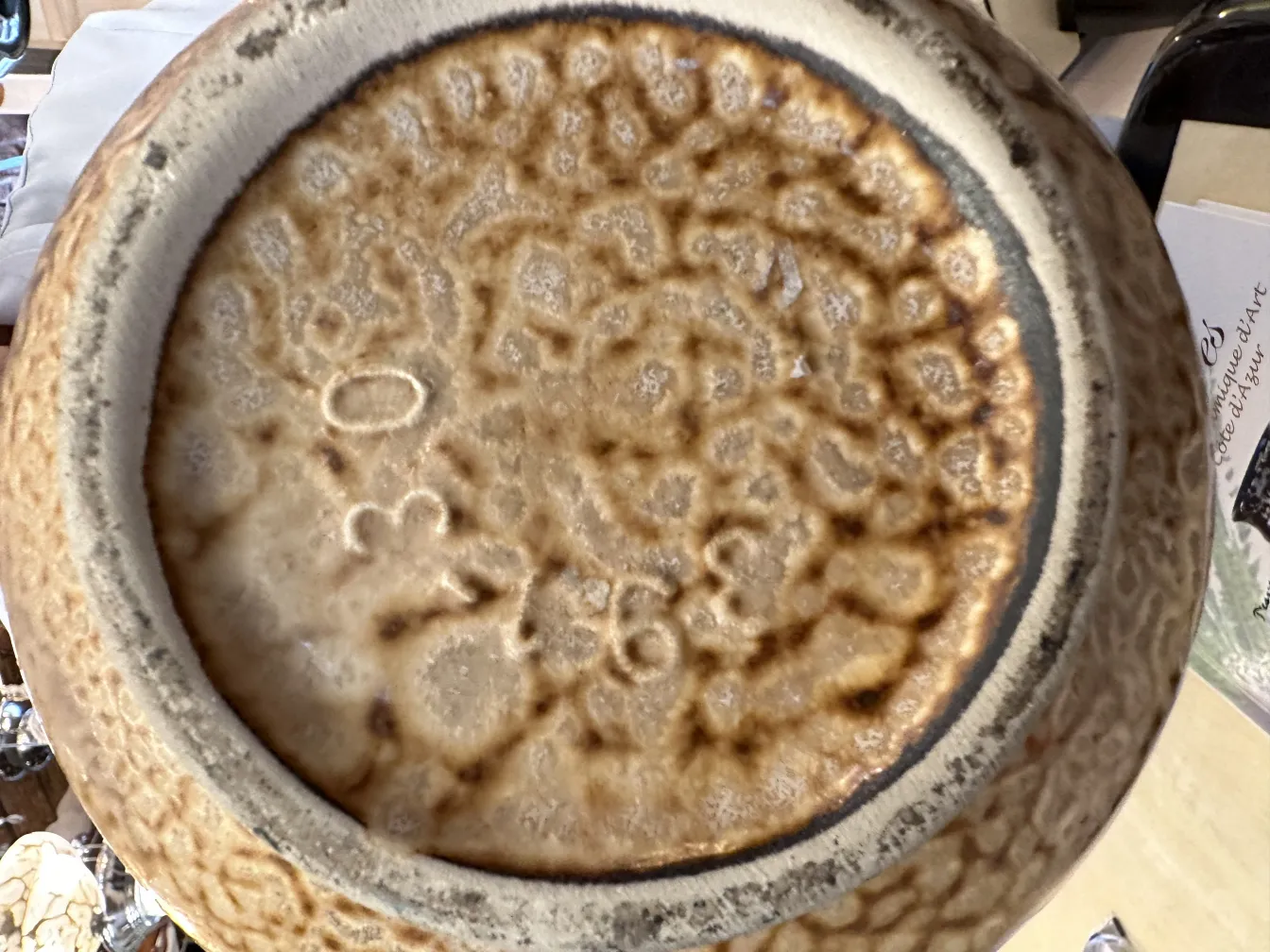 古い陶器のふた、自然な質感と目に見える印。