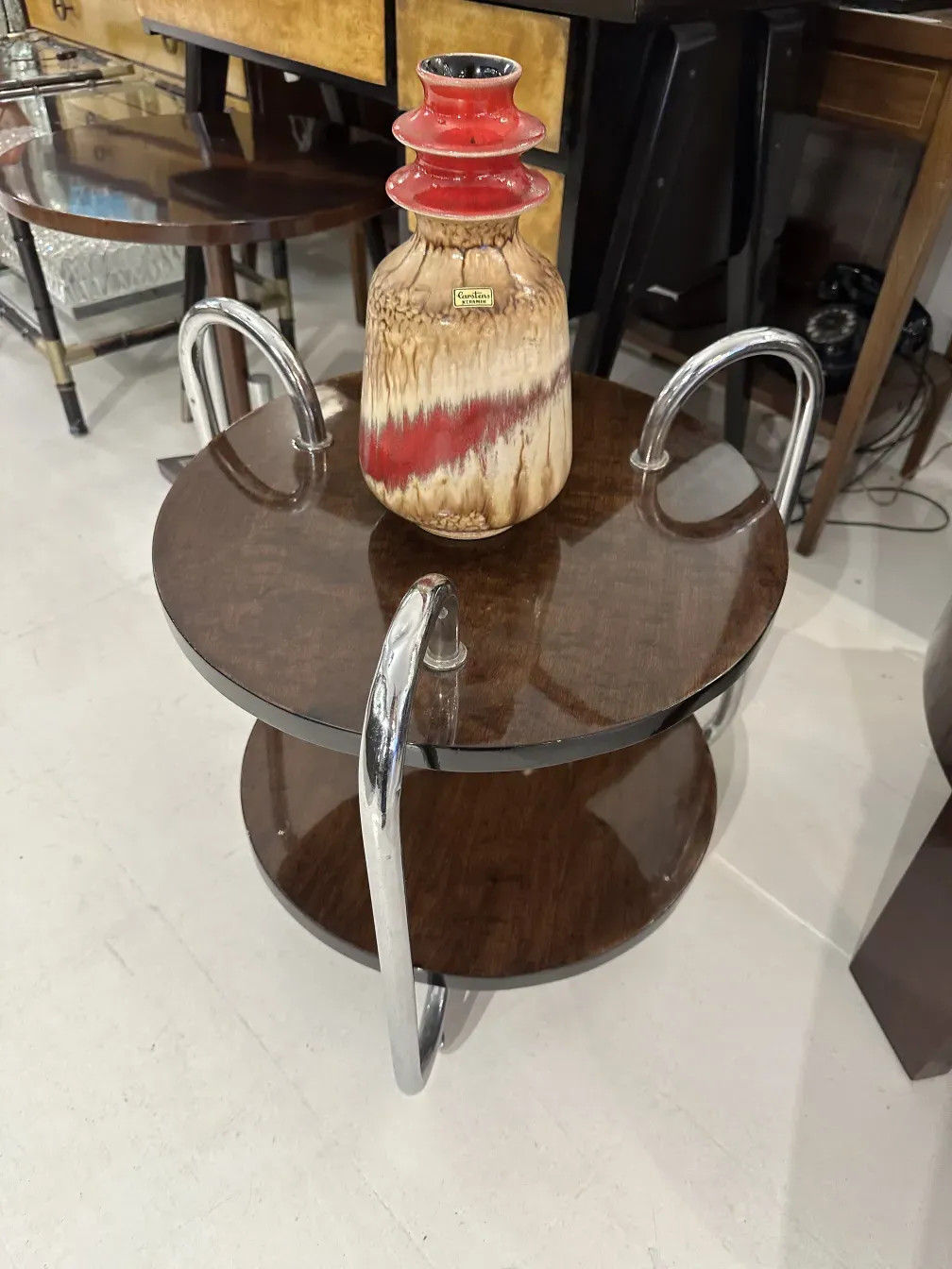 Vaso de cerámica antiga com decorações em tons quentes em uma mesa.
