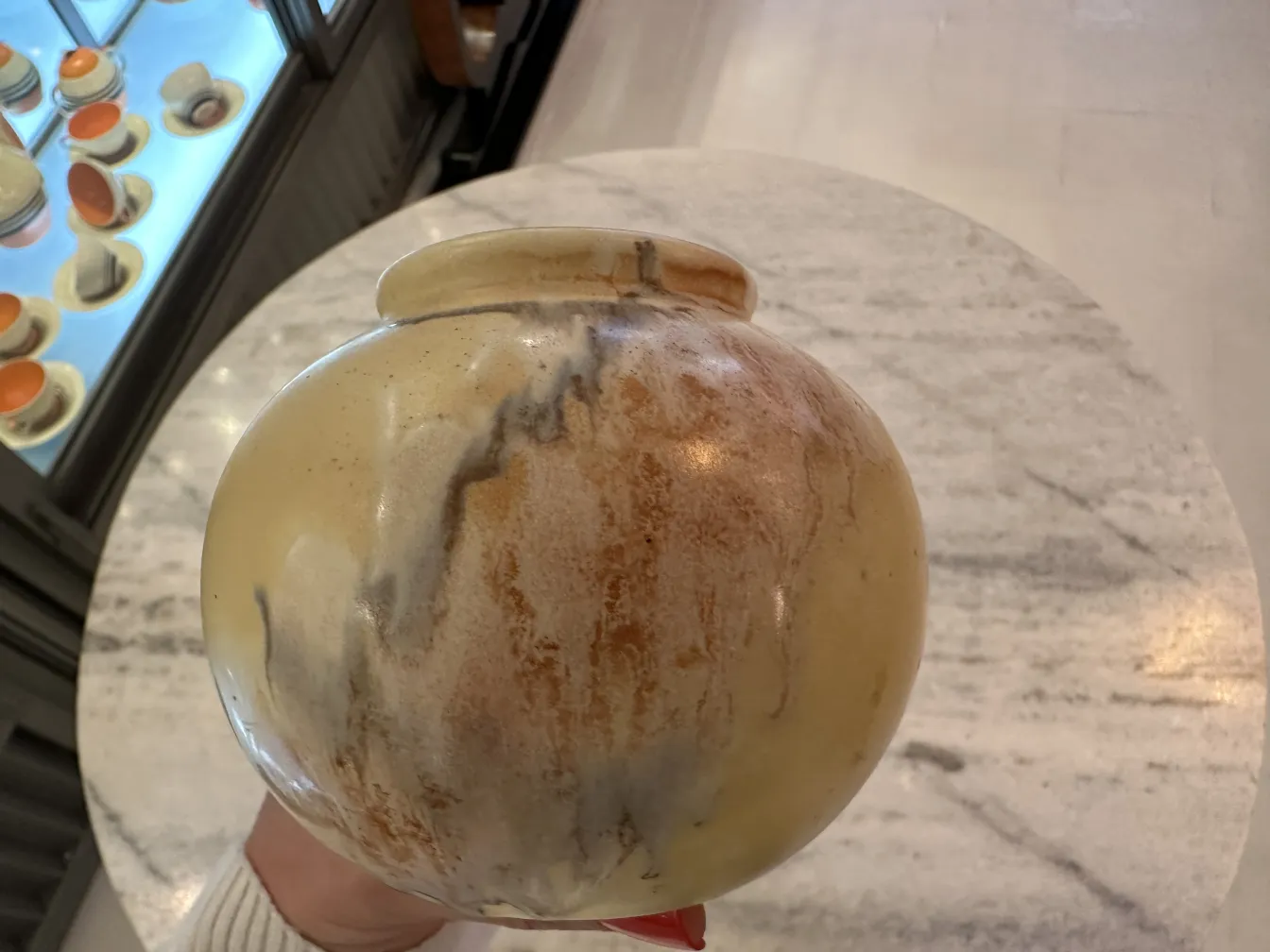 Vaso de cerâmica antiga com tons de marrom e creme