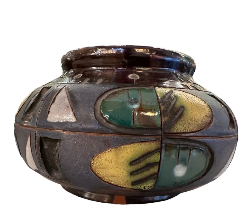 古代の陶器の花瓶、鮮やかな色と装飾的なパターンを持ち、柔らかな背景に置かれています。