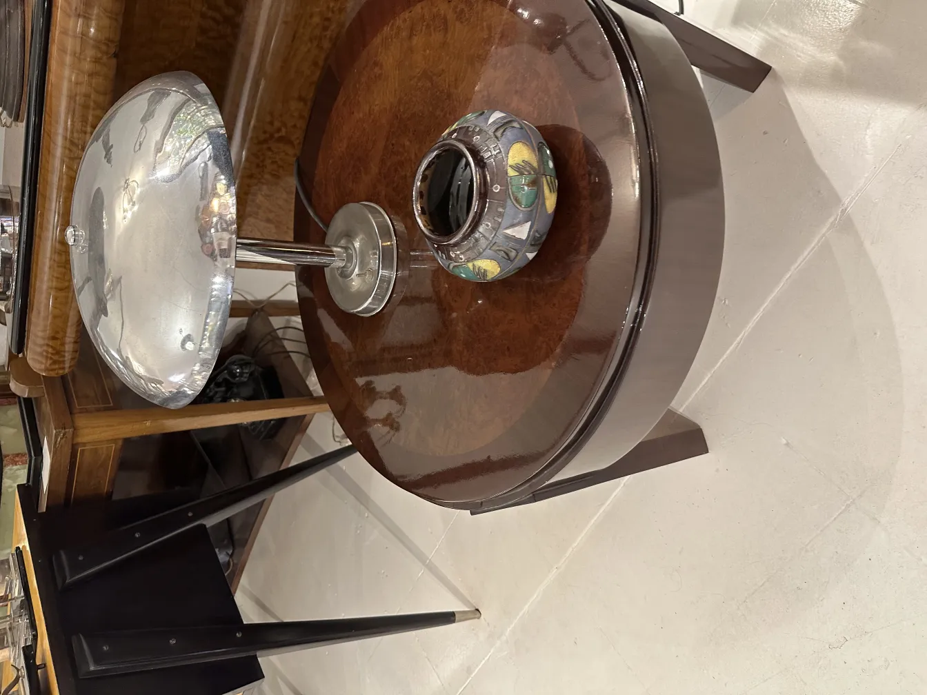 Metalllampe auf Tisch mit bunter Keramik in der Mitte