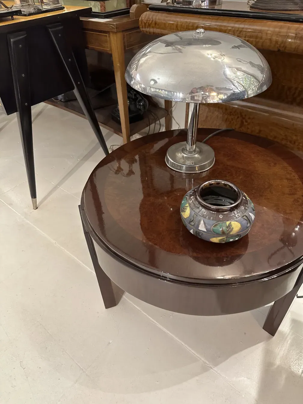 Pezzetto di ceramica antica dai colori vivaci in un ambiente elegante con lampada e tavolo.