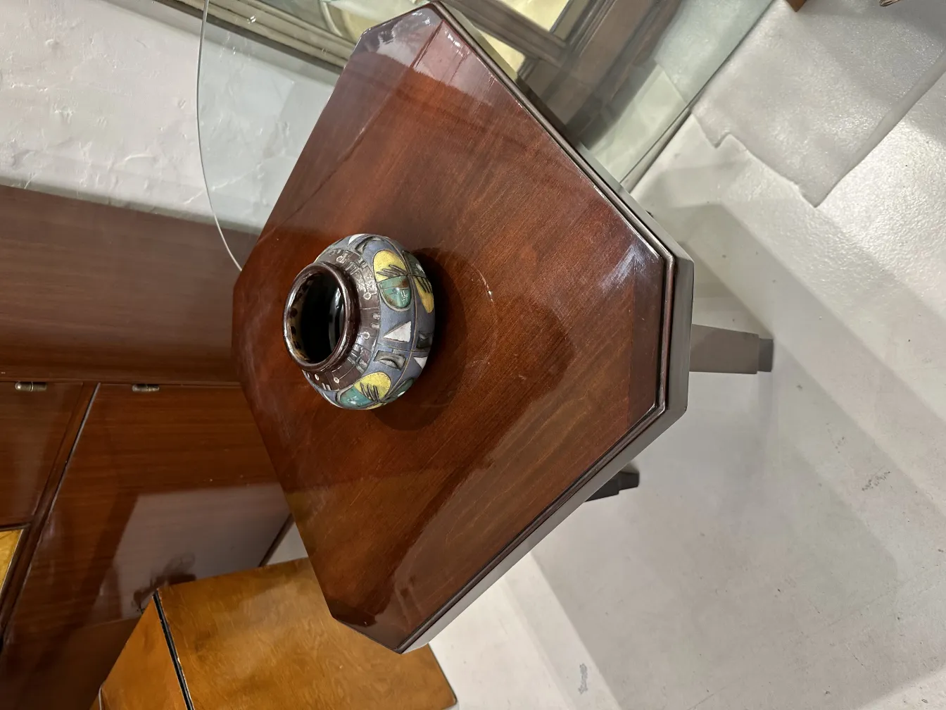 Cerámica antigua decorativa con botones de luz, presente en mesa de madera.