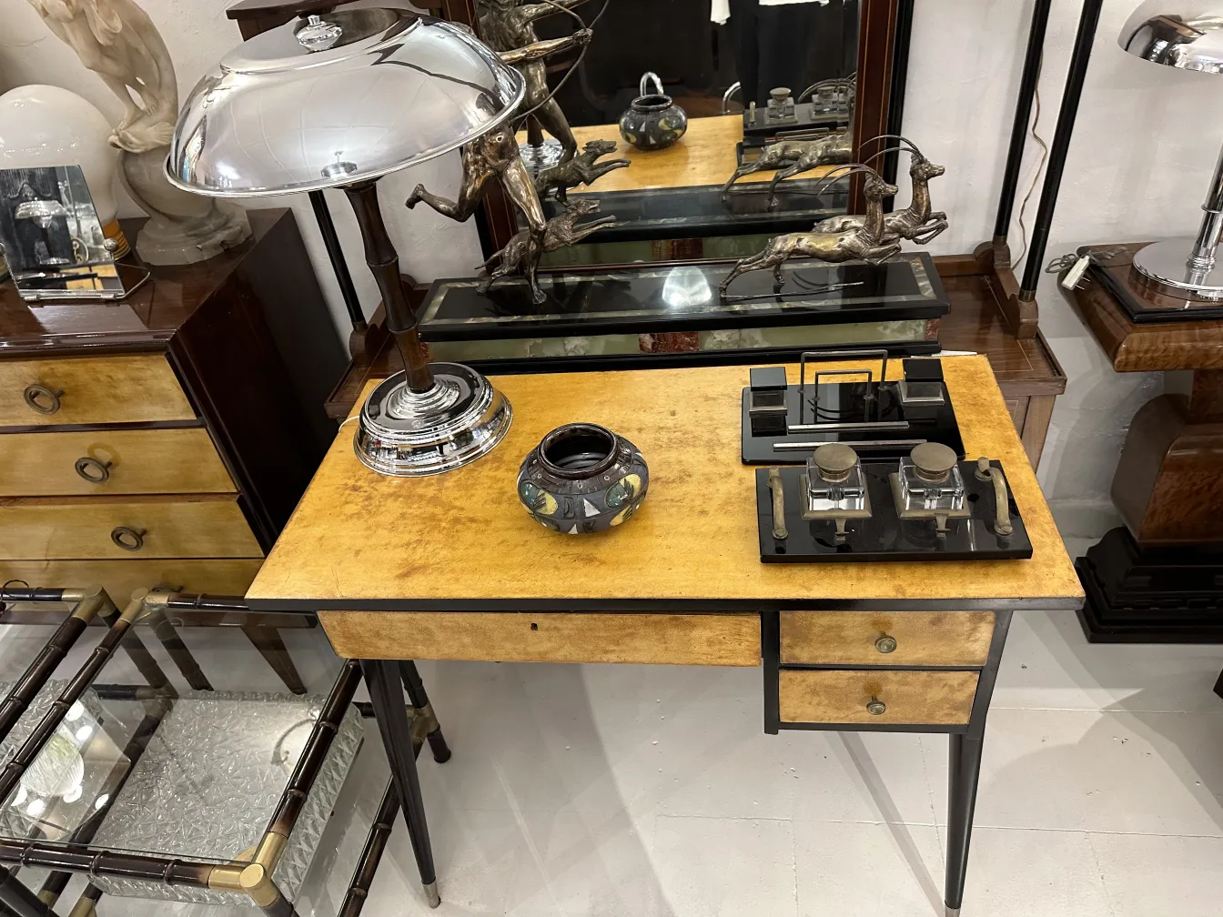 Cerâmica antiga decorativa em mesa com lâmpada e objetos