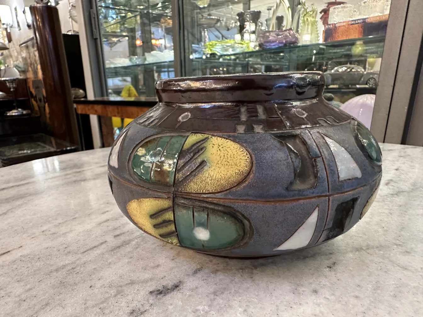 Ceramica decorativa antica con colori vivaci in un ambiente di antiquariato.