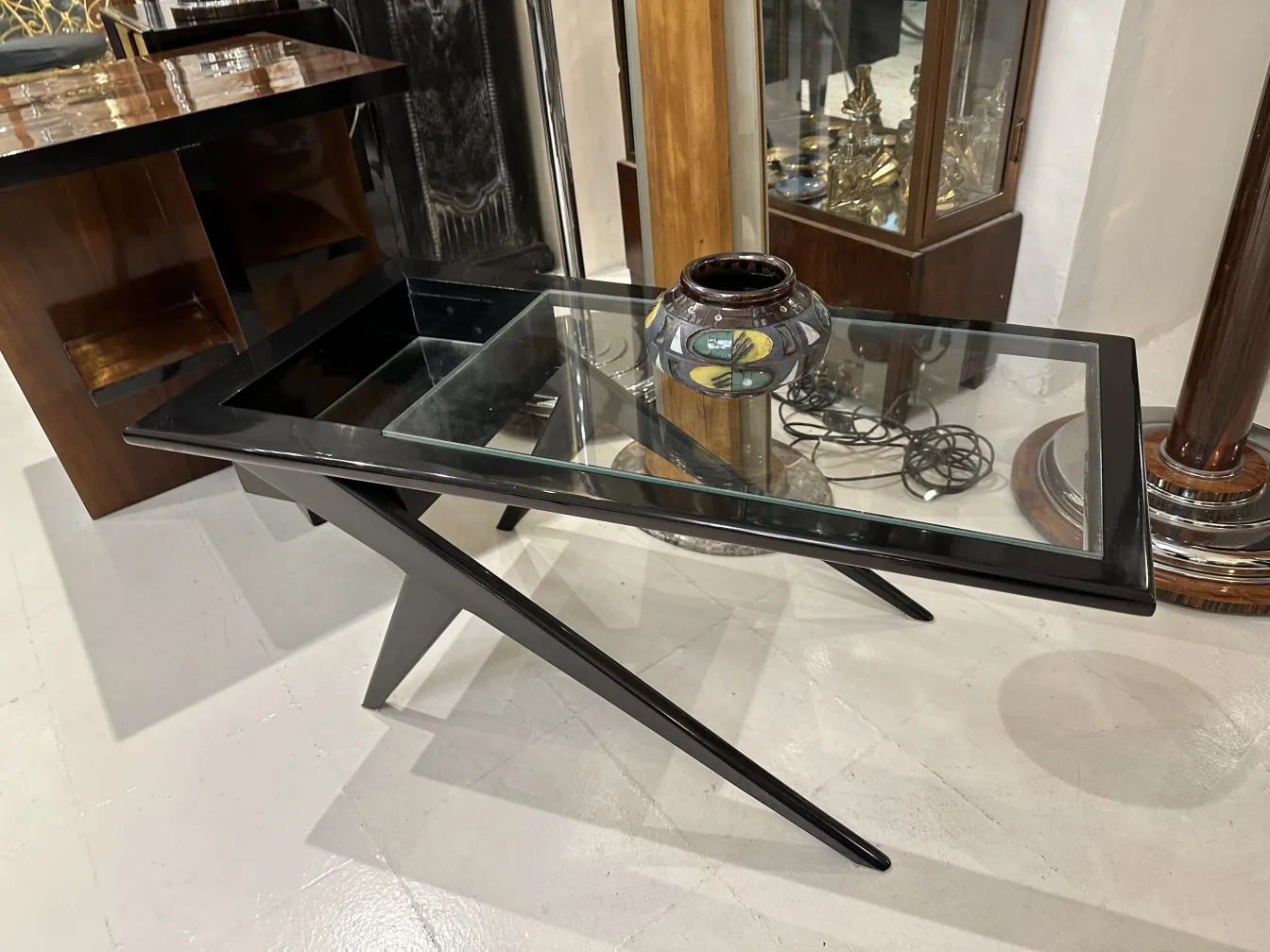 Jarrón de cerámica decorativa sobre mesa moderna de vidrio.