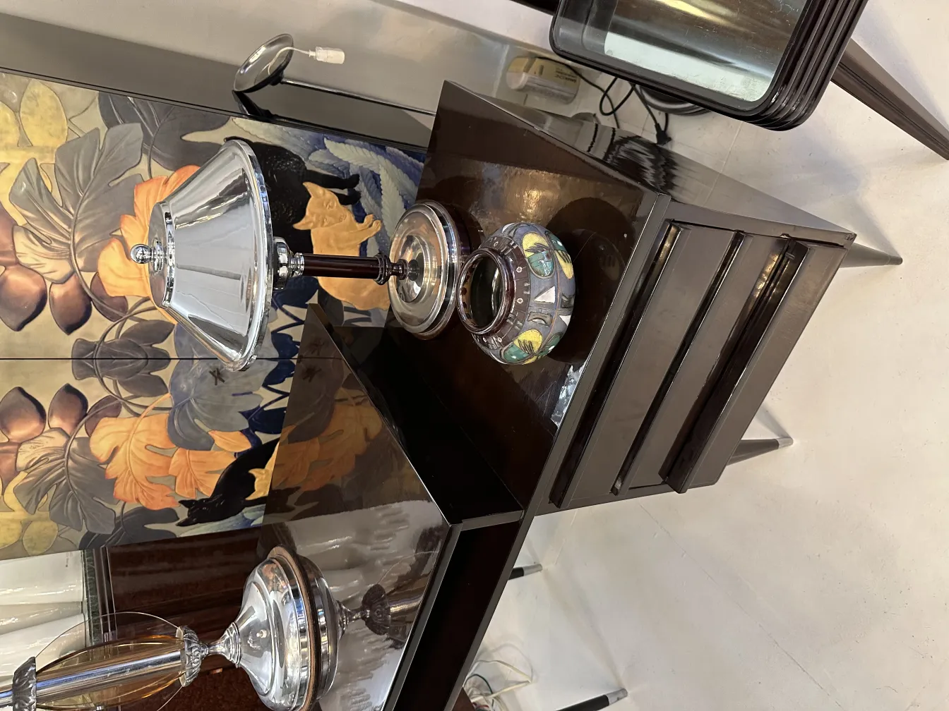 古い装飾用陶器が色鮮やかなデザインで、暗い背景にあります。ランプとモダンな要素を含みます。