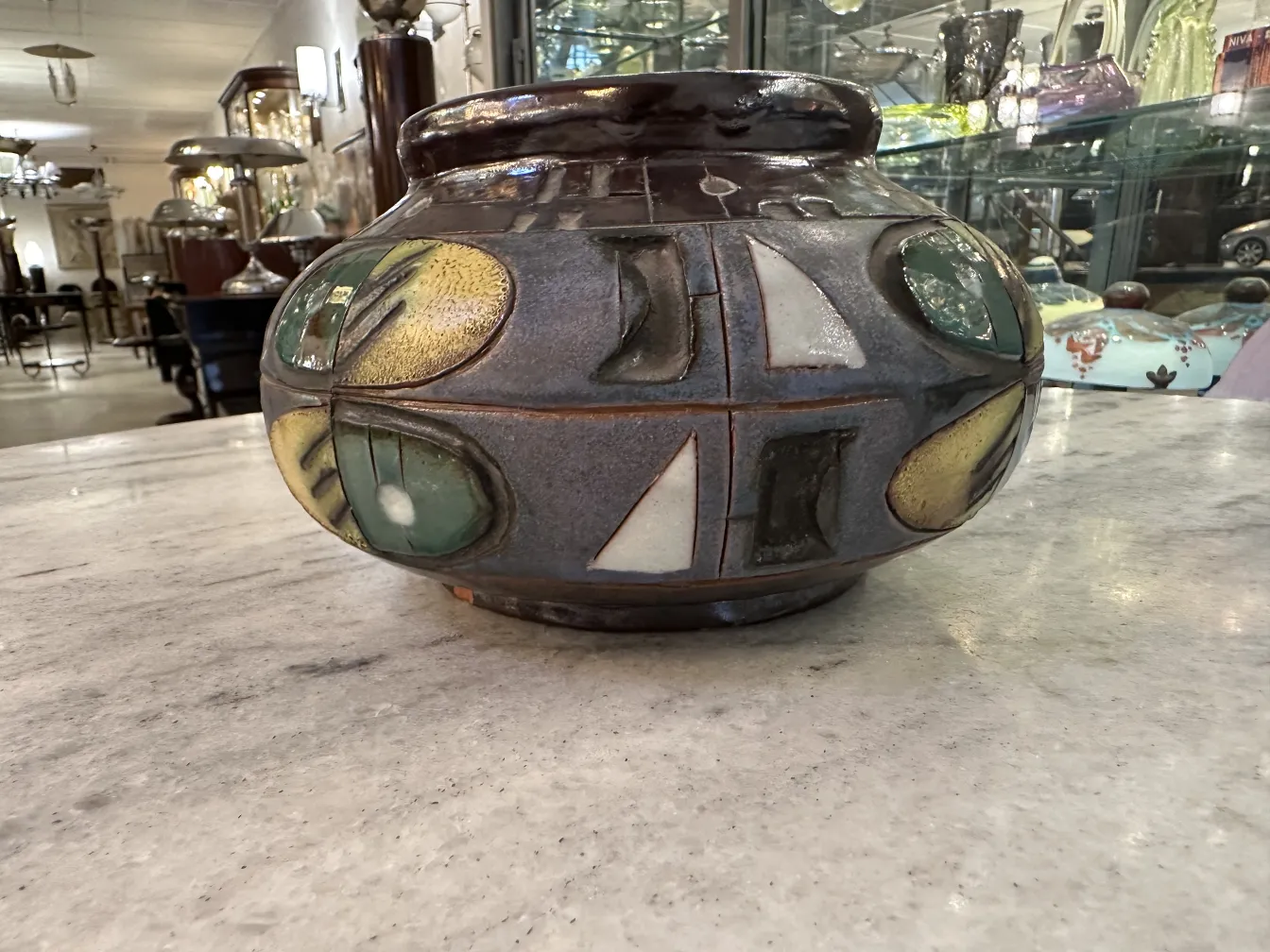 Antiker Keramikvase mit bunten grünen und gelben Dekorationen.