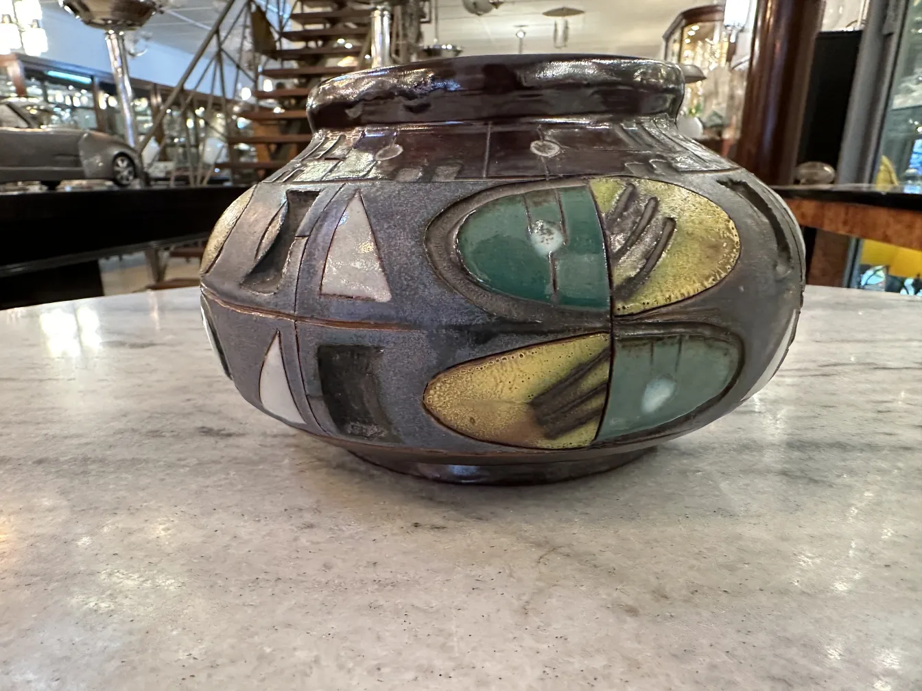 Antique ceramic vase with colorful designs on marble tables