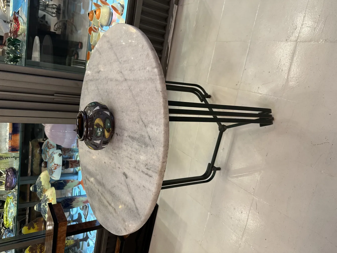 Vaso in ceramica antica con dettagli unici su un tavolo elegante. Sfondo decorativo con pezzi colorati.