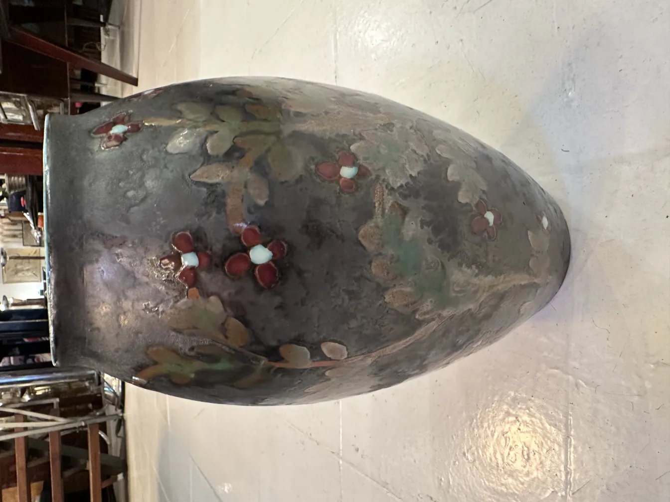 Vaso in ceramica antica con dettagli floreali e colori morbidi