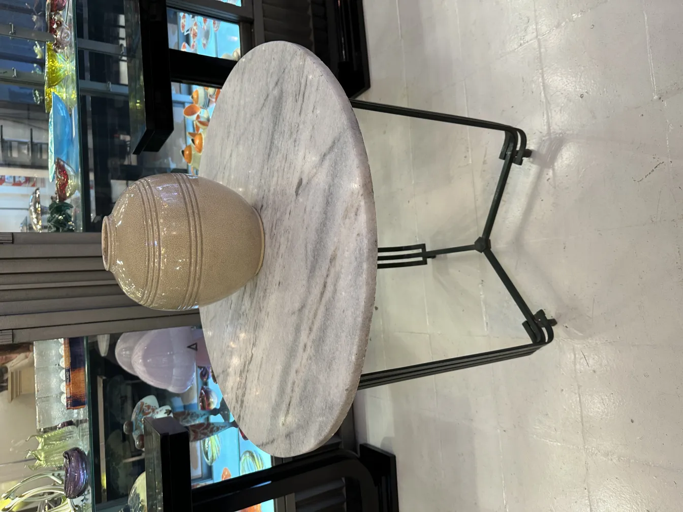 Vaso in ceramica antica su tavolo rotondo decorativo.