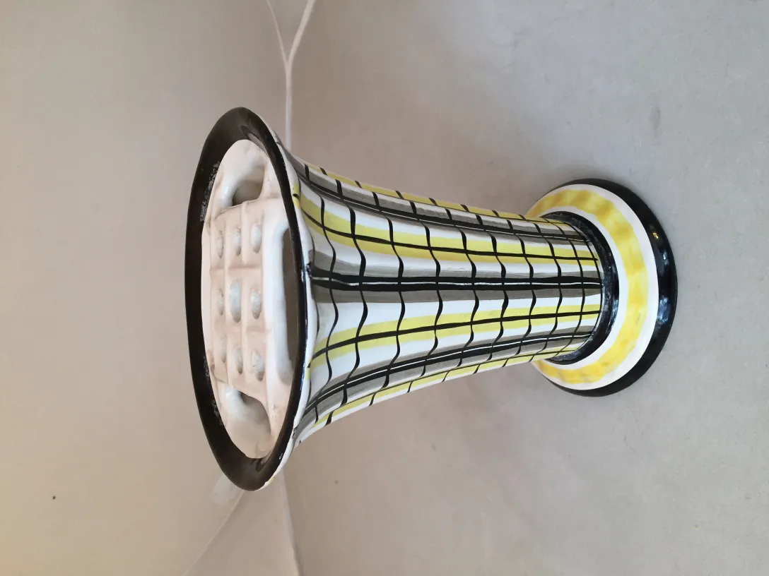 Vaso de cerâmica antiga com design de listras amarelas e pretas.