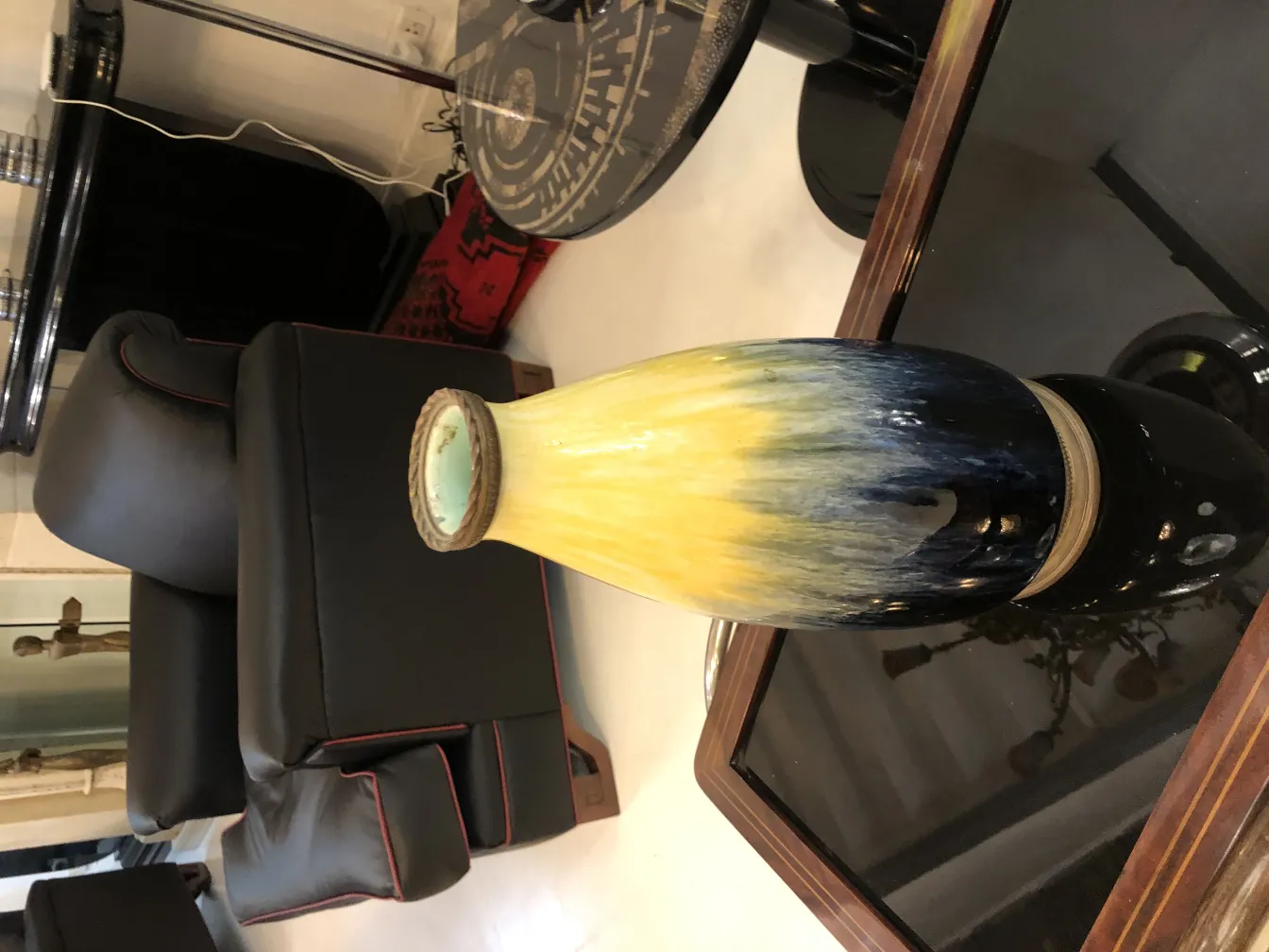 Vaso antico in ceramica con tonalità gialle e blu in un ambiente moderno