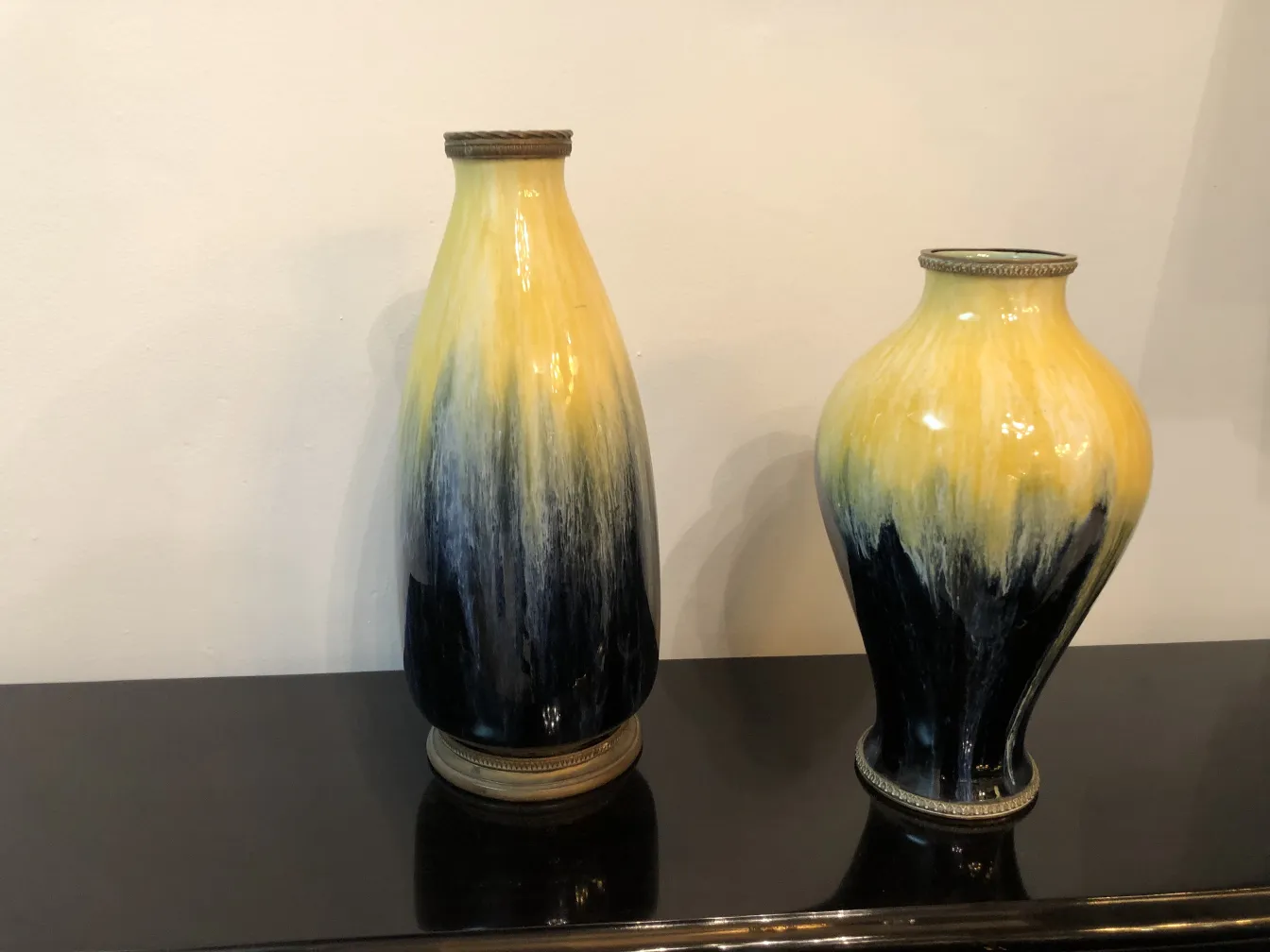 Deux vases en céramique anciens en nuances de jaune et de noir.