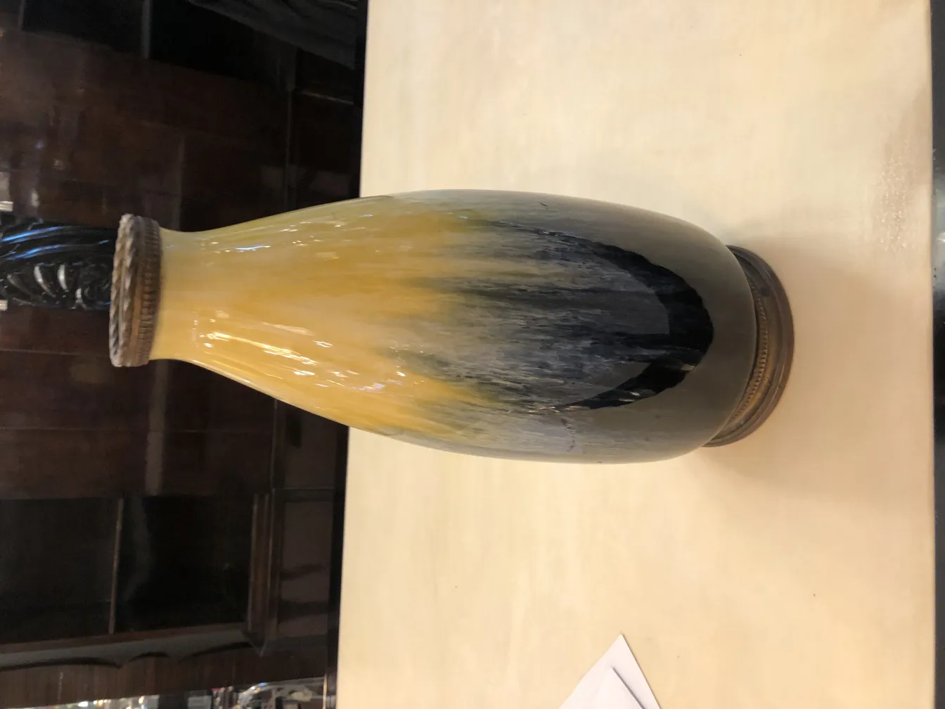 古代陶瓷瓶装饰有黑色和黄色，背景中性