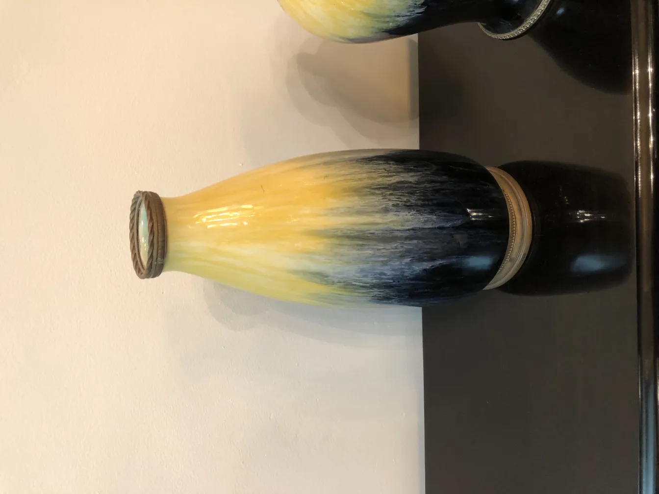 Basis alter Keramik mit bernsteinfarbener und schwarzer Farbe, auf neutralem Hintergrund.