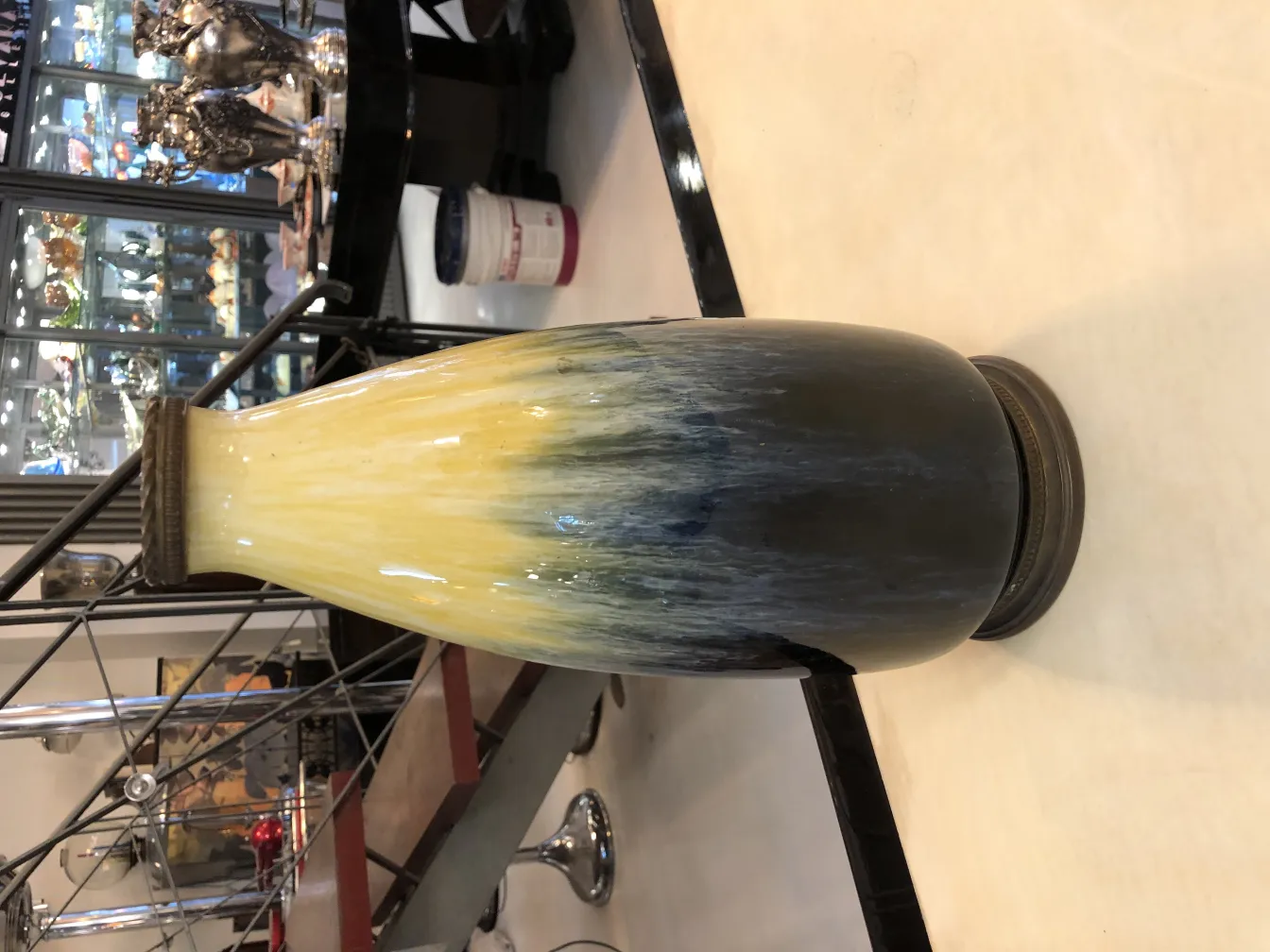 jarrón antiguo de cerámica con degradado amarillo y negro en un ambiente elegante.