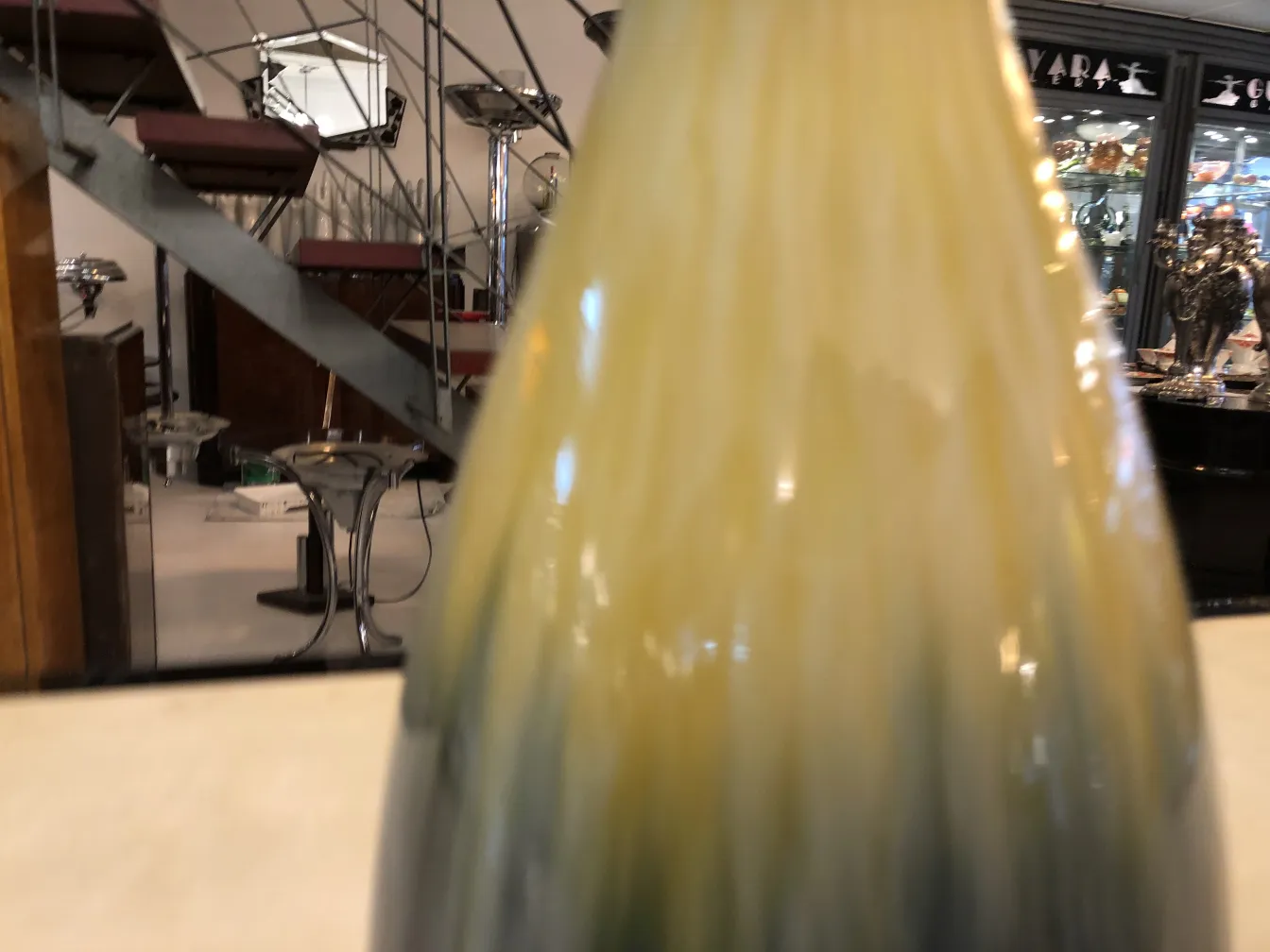 Botella de cerámica antigua de Boch frères con tonos amarillos y verdes.