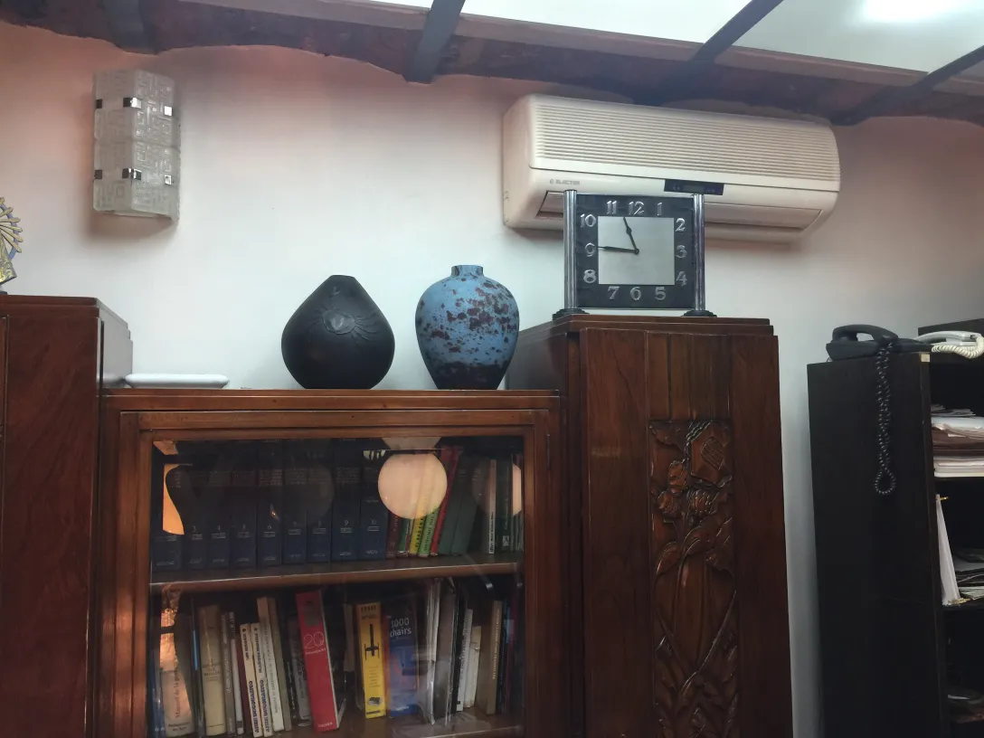 Elegante ceramica antica in tonalità scure e blu su un ripiano.